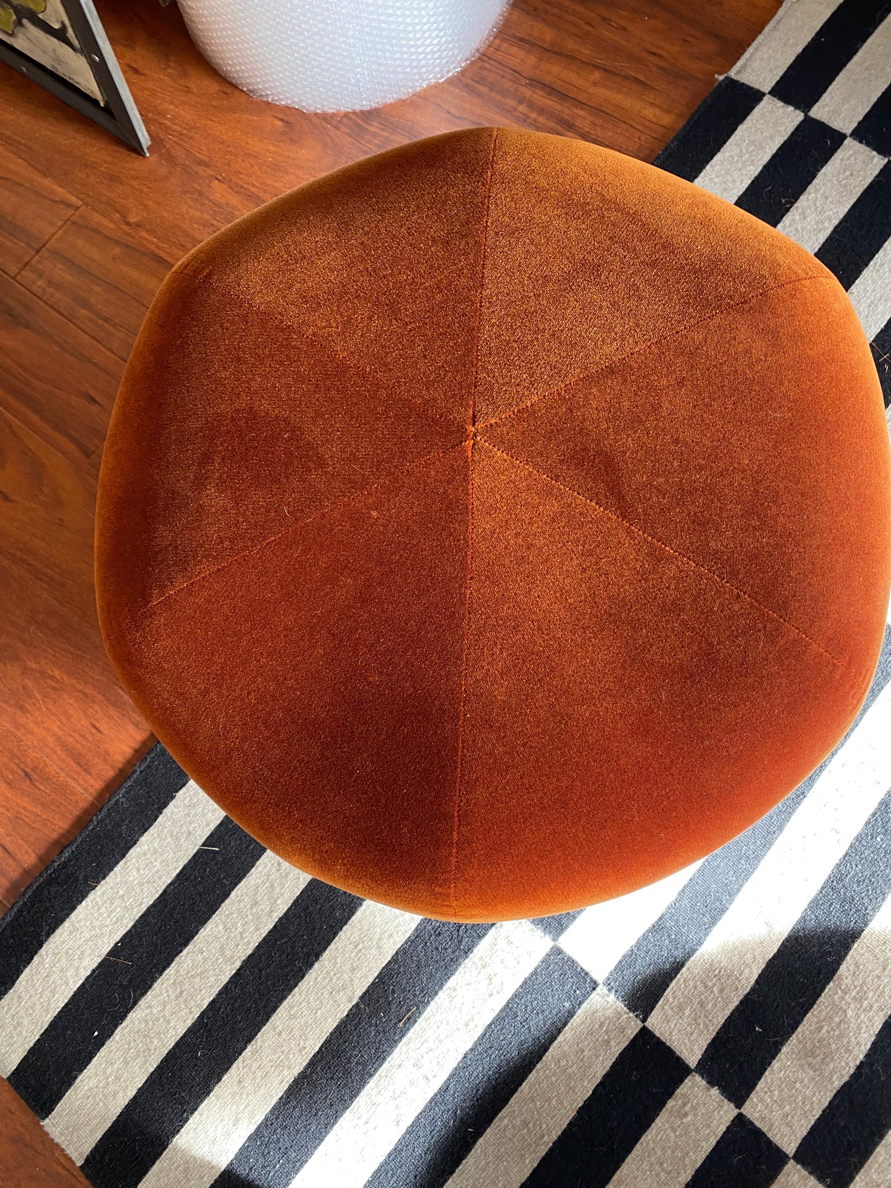 This contemporary brick-colored ottoman combines modern elegance with everyday comfort. Upholstered in high-end velvet, its soft texture enhances both visual and tactile appeal. The cylindrical shape and muted tone offer a refined, understated
