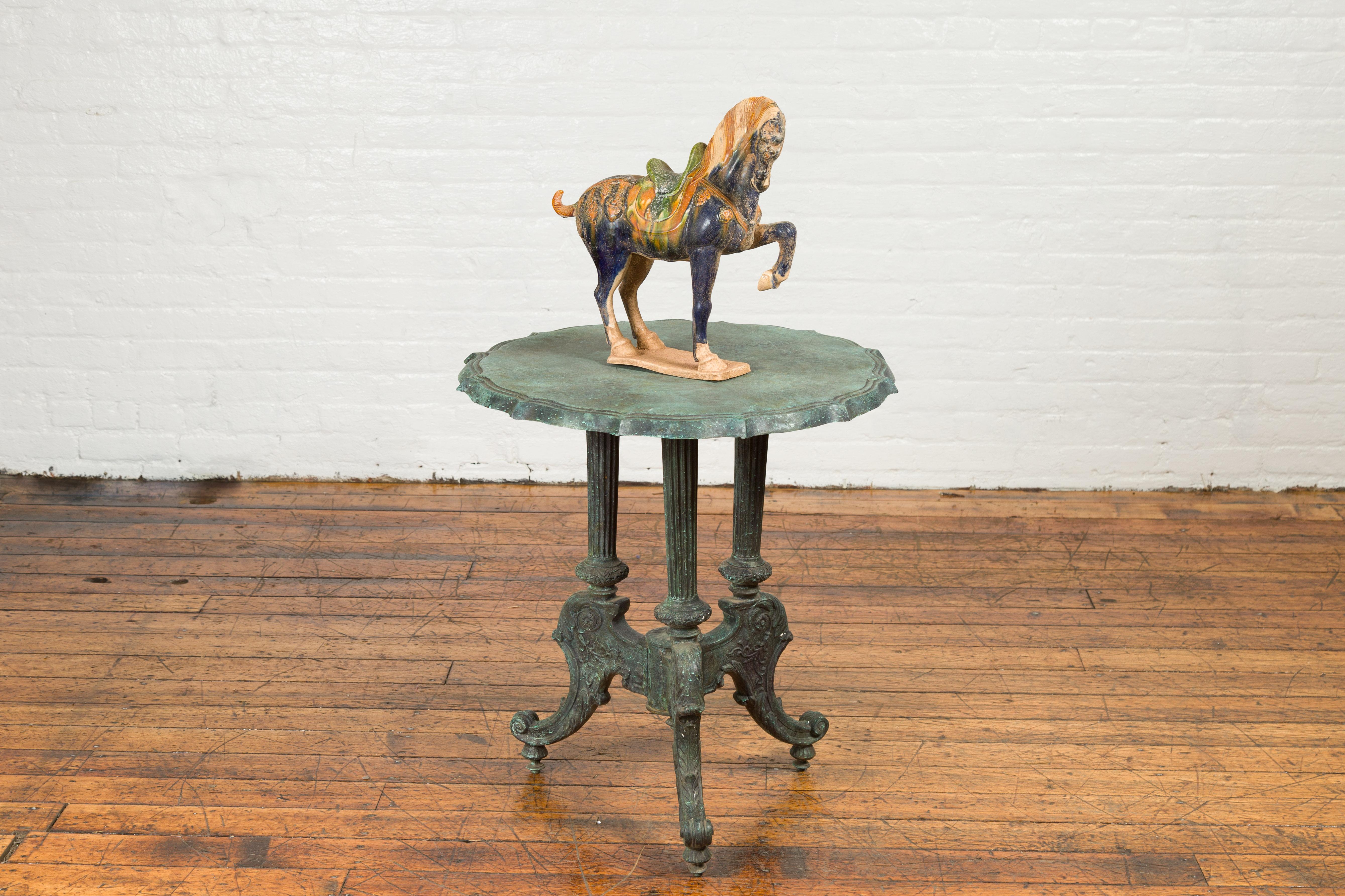 A verde bronze guéridon side table with pie crust top, fluted legs and scroll feet. Created using the traditional lost-wax technique (à la cire perdue), which allows for exquisite precision and detail, this contemporary verde bronze side table