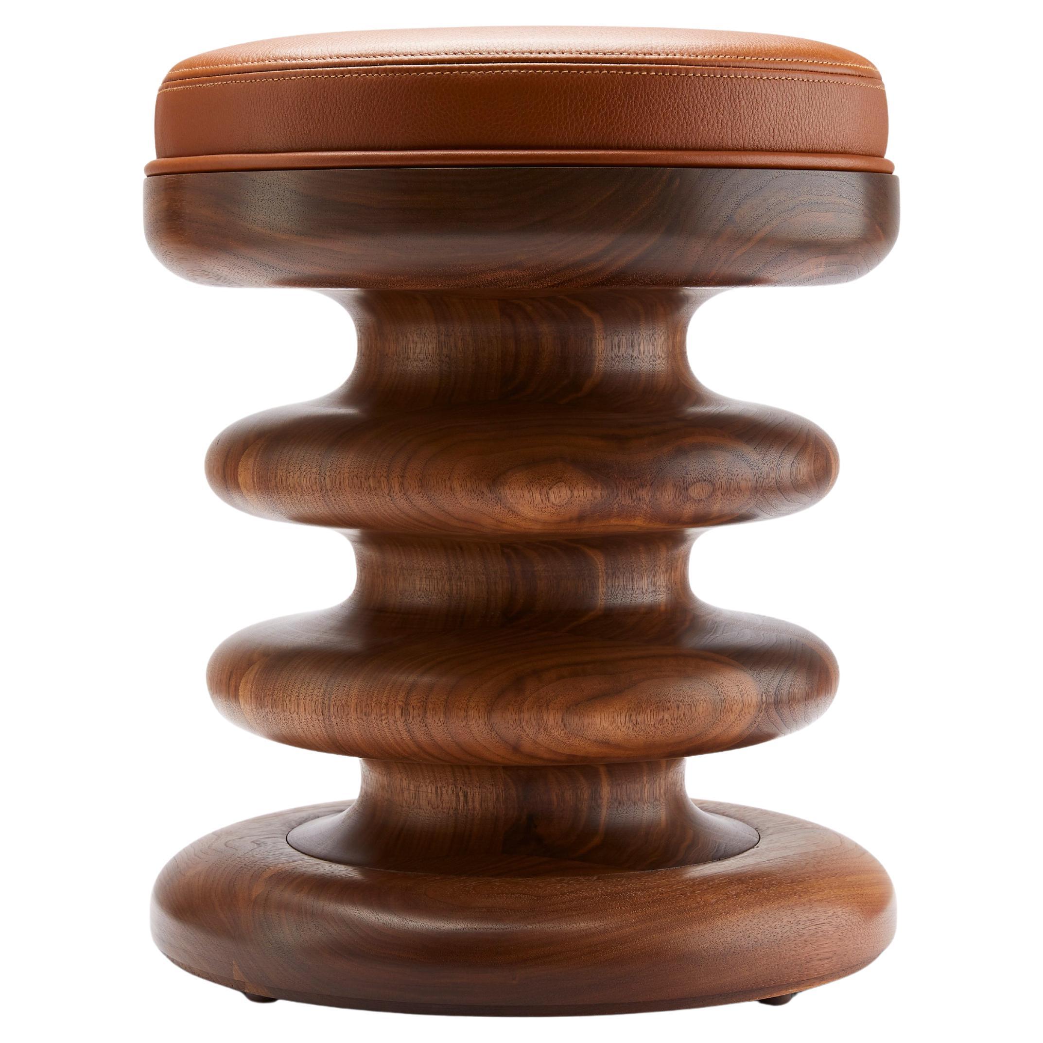 Der aus massivem amerikanischem Schwarznussbaum gedrechselte Vertere Midi Hocker hat eine übertrieben skulpturale Silhouette, die die atemberaubende Schönheit des Nussbaums voll zur Geltung bringt. Wir empfehlen ein geöltes Finish, um die Wärme und