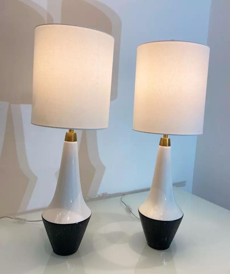 Paire de lampes de table contemporaines monochromes de Visual Comfort et Ralph Lauren.

Avec un design noir et blanc, les lampes ont des détails en laiton et sont associées à des abat-jours en lin crème. 

D'un design Elegant, ces lampes sont des