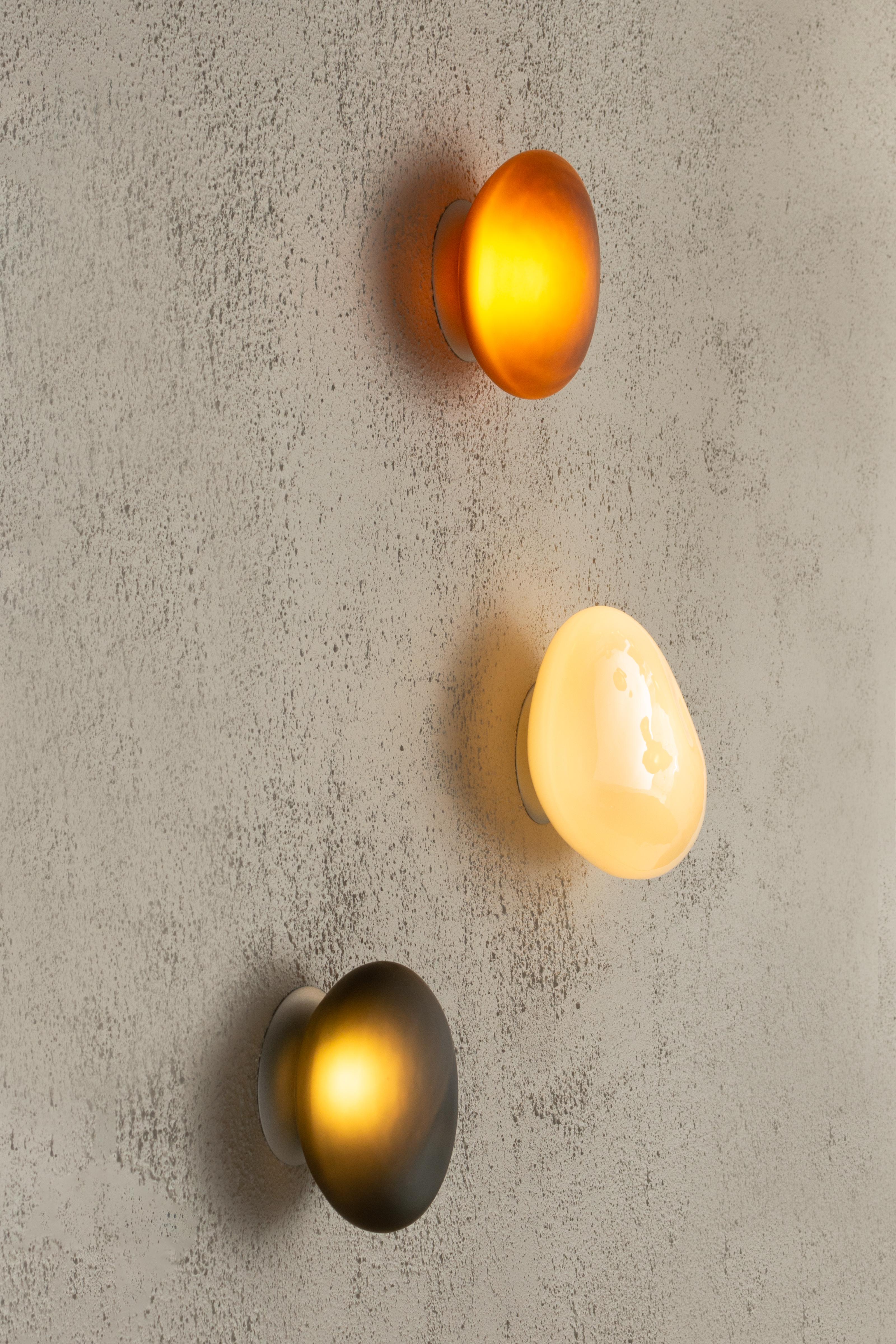 Contemporary wall lamp pebble 

Electrical : 
Voltage: 110 – 277V / 220 – 240V
Integral LED source : 1 x 9W LED

The model shown in picture:
Dimensions: A: 30.5 x 21 x 18 cm 
Color: Citrine
______
Pebble
The Pebble series celebrates the