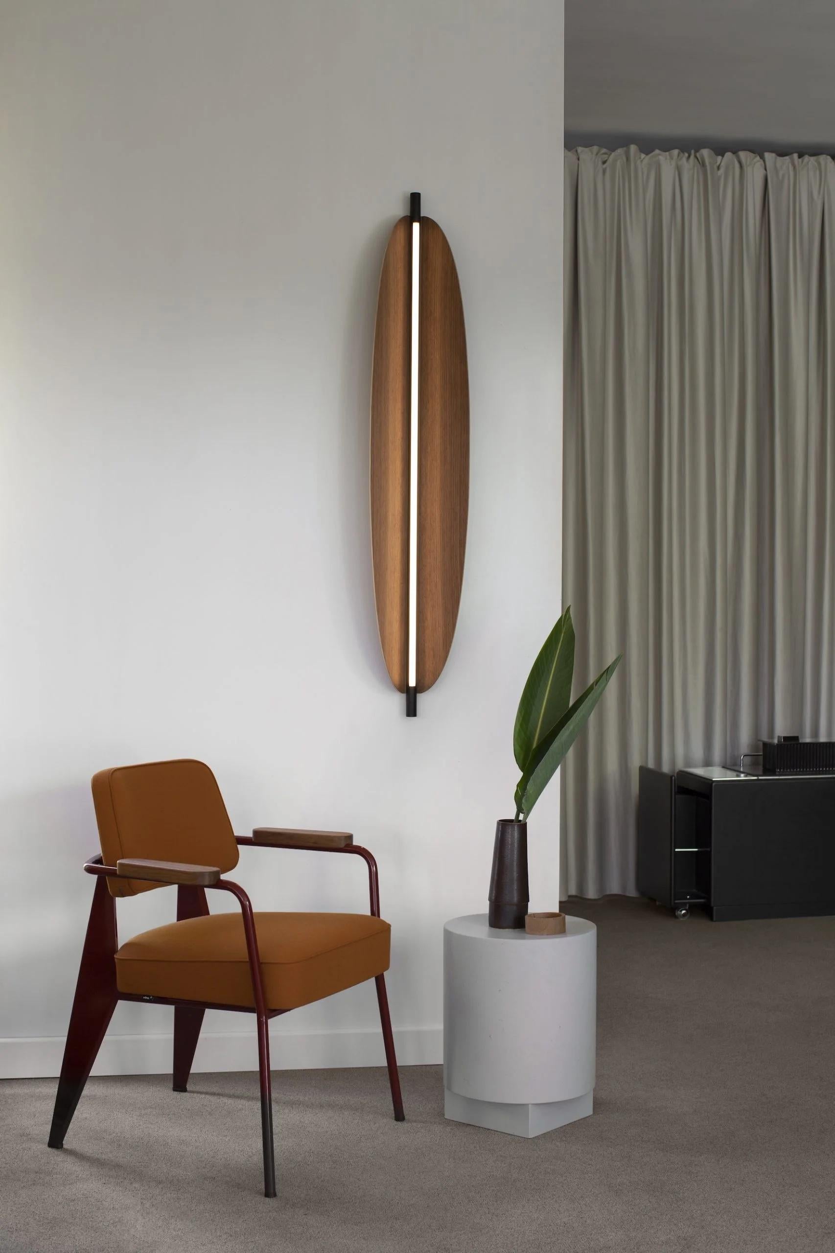 Thula 562.43 by Frederica Biasi x Tooy
Wall lamp
Compliant with USA electric system

Model shown: 
- hardware Sand black 
- details Sand black
- shade Canaletto walnut

Materials: aluminum, metal, leather, wood

The Thula wall lamps are based on a