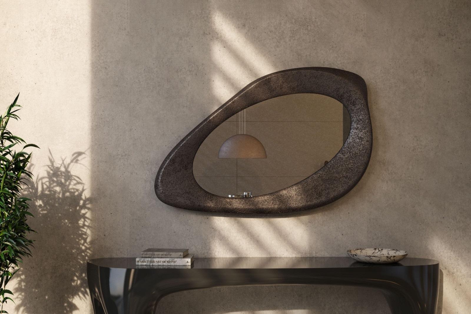 Experience the allure of this wall mirror, a striking addition to modern interiors. Its fluid contours, textured volcanic surface, and bronzed reflection make a bold visual impact, infusing depth and personality into any room. Crafted with precision