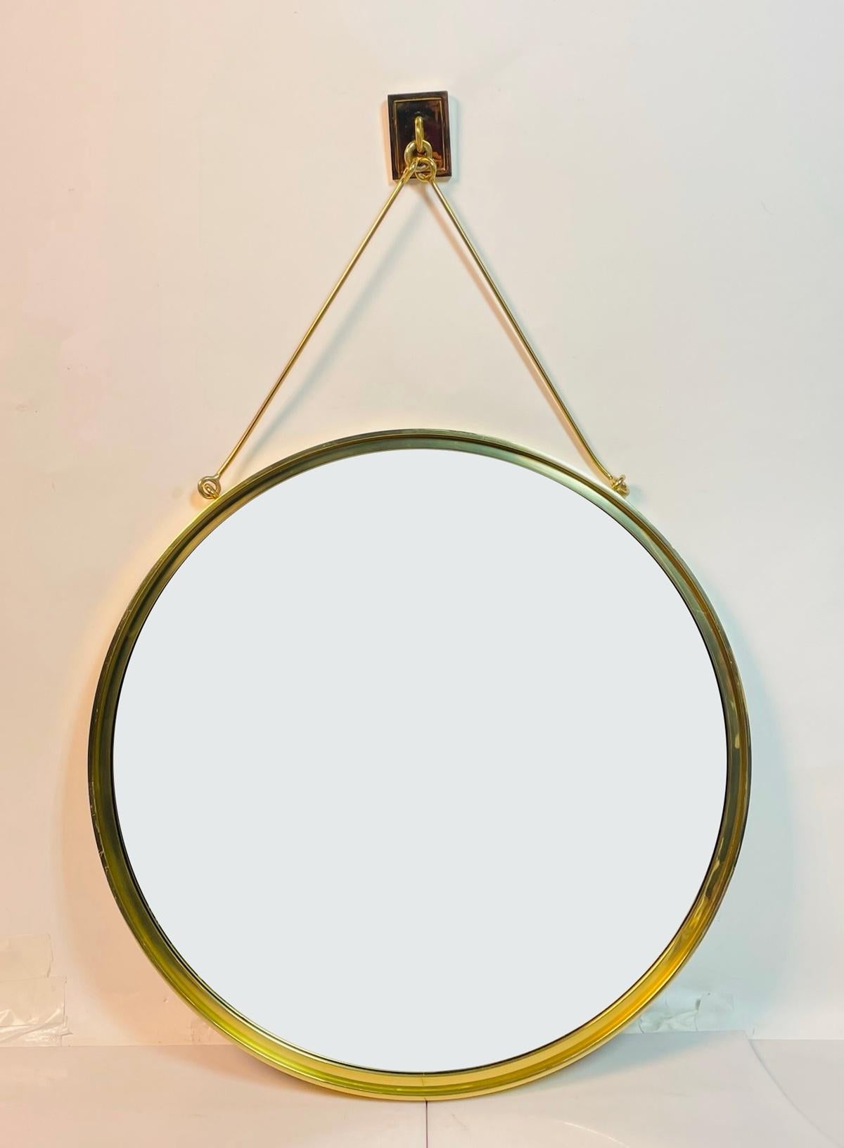 Add a touch of modern elegance to your space with the Contemporary Wall Mounted Brass Mirror by Waterworks. Crafted from high-quality brass, this stunning round mirror features a sleek gold finish that exudes sophistication. The unique stretcher