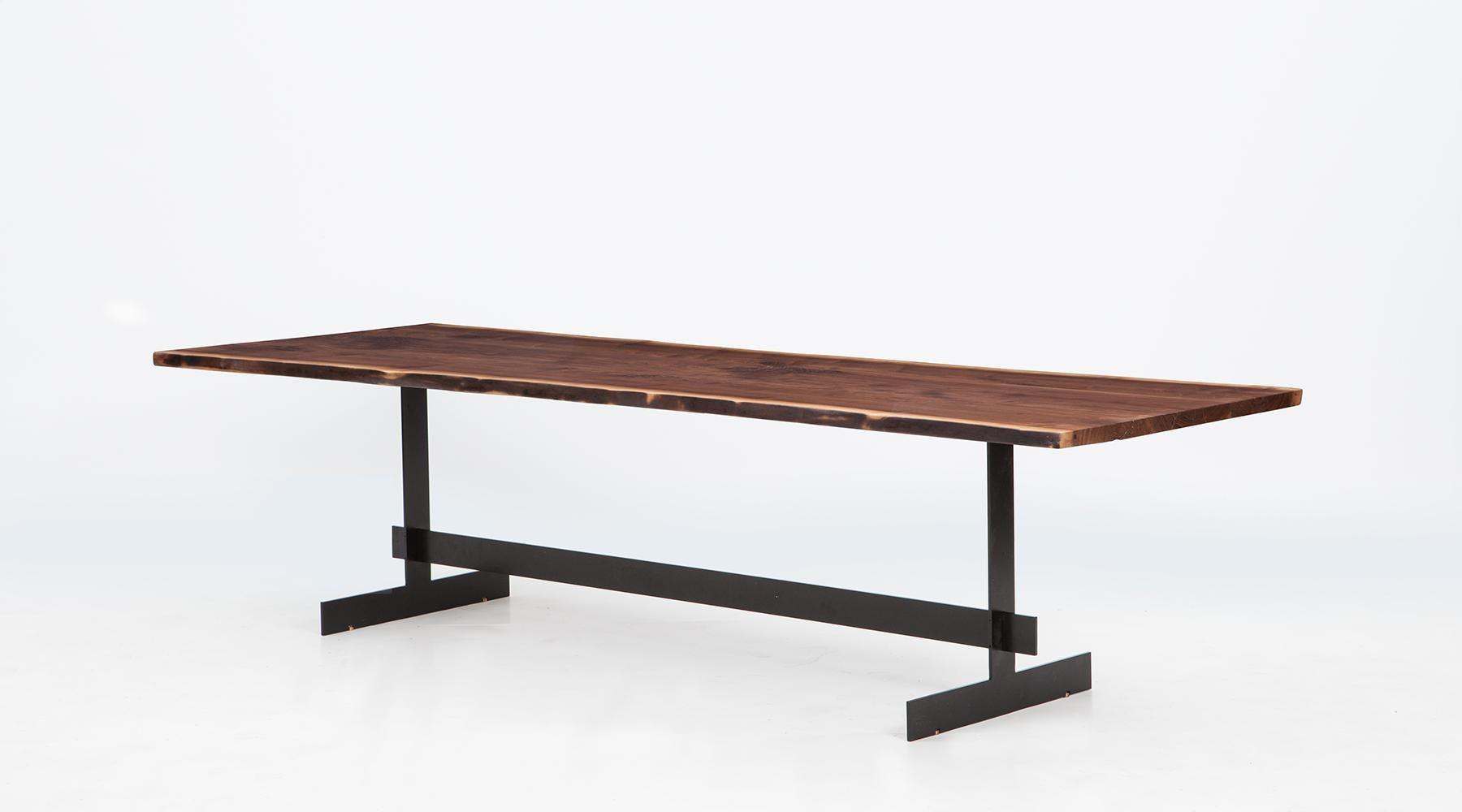 Table by contemporary German artist Johannes Hock. Massive walnut top on massive black lacquered metal base. Manufactured by Atelier Johannes Hock.

The shape is Inspired by an originally monastery table consisting of trestle and plate. Live edge
