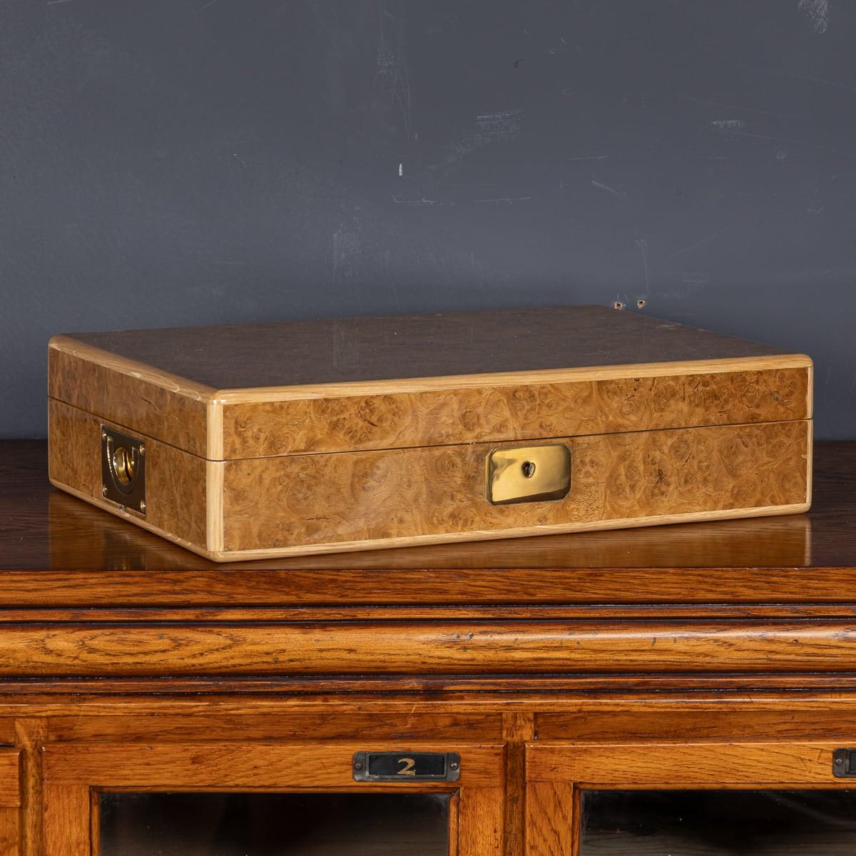 Featuring a sleek contemporary design, this modern 21st Century watch case showcases an oak carcass with brass hinges and lock, covered in a fine pollard oak trim. Upon opening, it reveals a meticulously crafted interior with eight custom-made