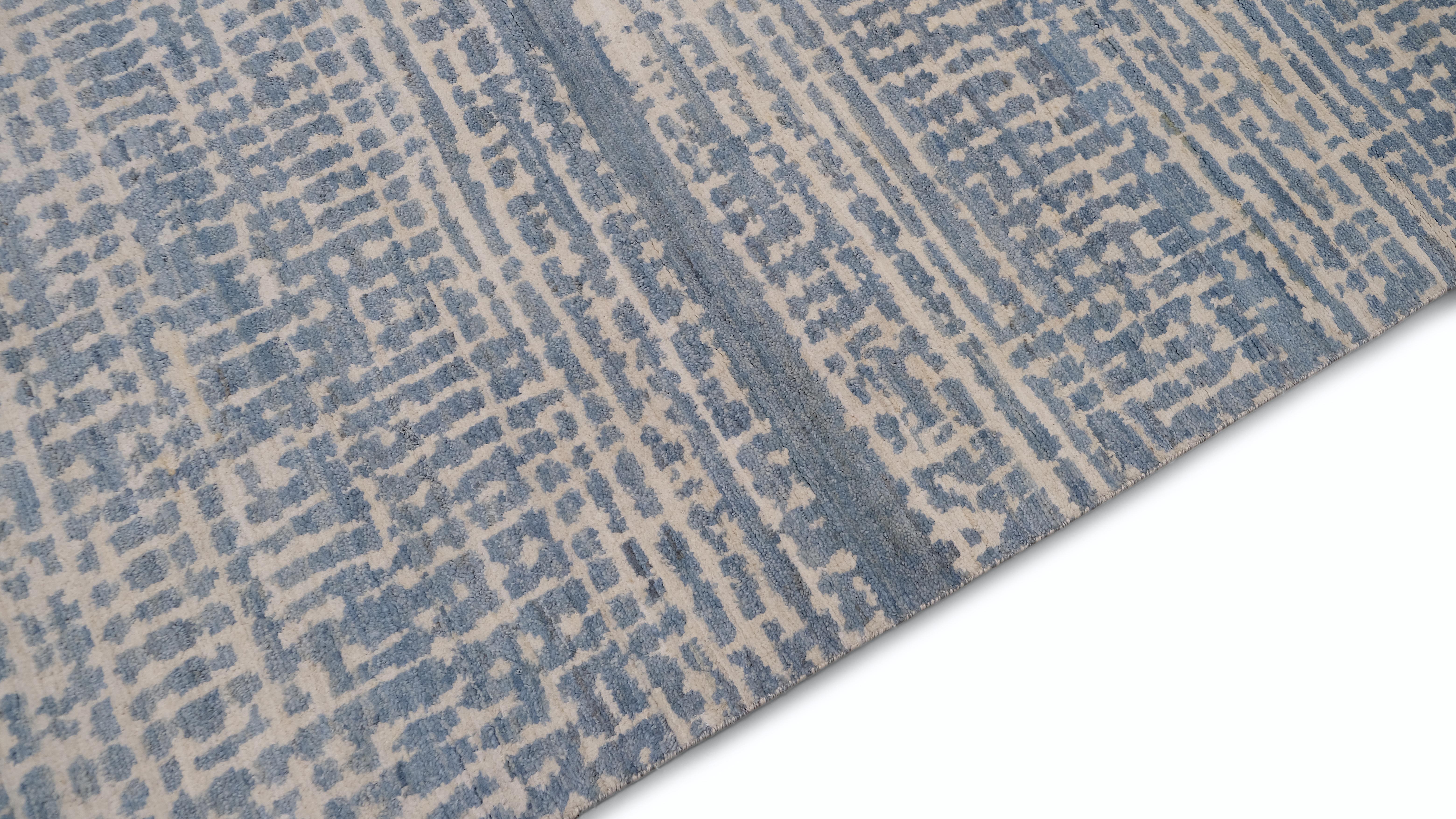 Ce superbe tapis en laine noué à la main rehausse votre décoration intérieure. Doté d'un motif abstrait dans des tons doux de bleu et d'ivoire, ce tapis allie sans peine l'art moderne à l'artisanat traditionnel. Le motif texturé ajoute de la