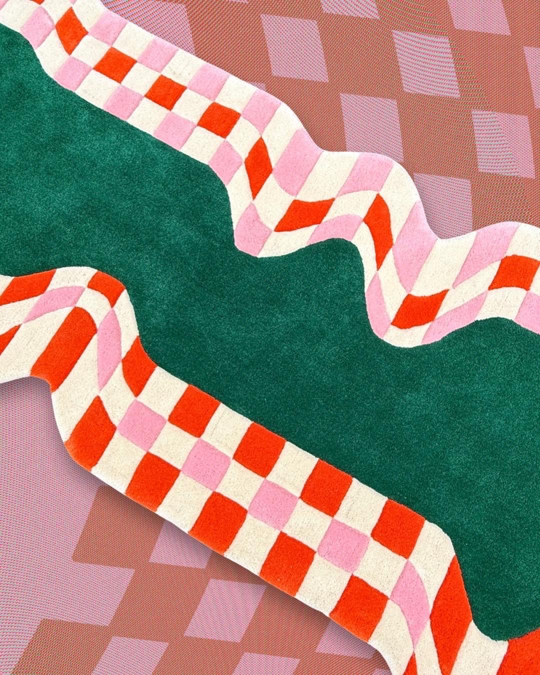 This contemporary rug reimagines the classic checkered motif with a playful twist. A bold red-and-pink checkerboard flows along wavy edges, framing a rich green center that instantly commands attention. Its organic silhouette and vibrant palette