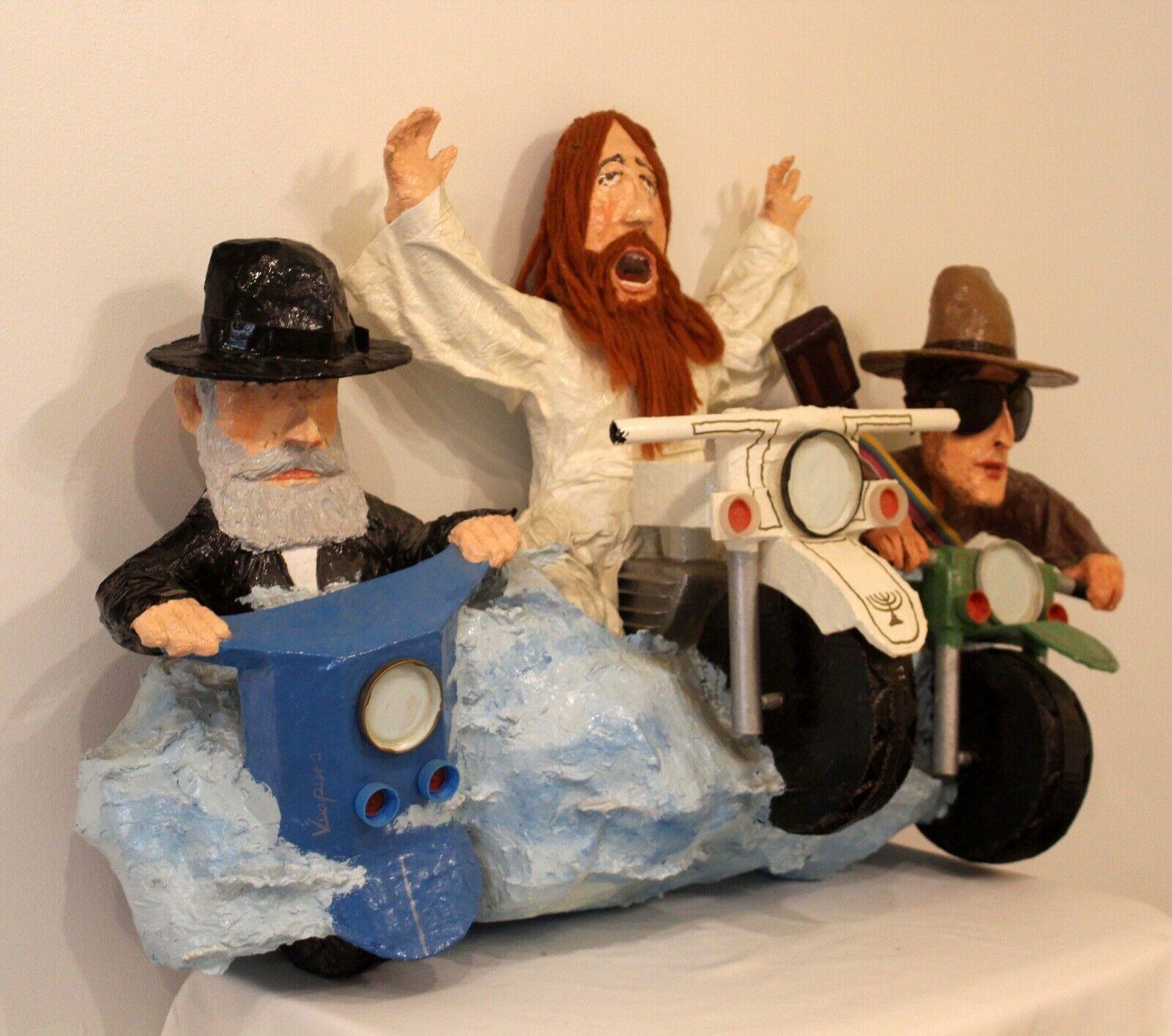 Der Hassidiker Rabbi und Bob Dylan, der auf einem Motorrad reitet, gehen mit Jesus auf die Straße, während er buchstäblich auf das Rad geht. Der Blick aller drei Charaktere strahlt Glanz aus, während sie auf diesem unkonventionellen Fahrrad durch
