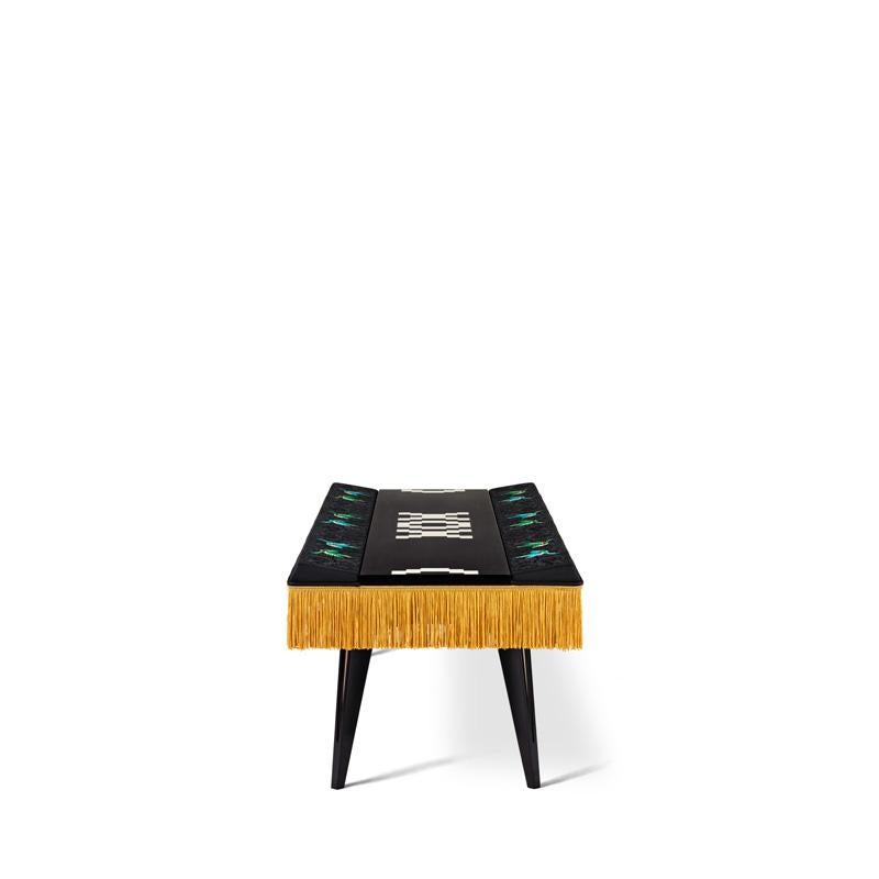 A visually striking black/white optical effect matched with fine embroidery.
Long small table with padded edges, embellished with a golden fringe and inlay wooden leaf to make a drawing on the top.
Solid beech legs. Semi gloss varnish.
The side