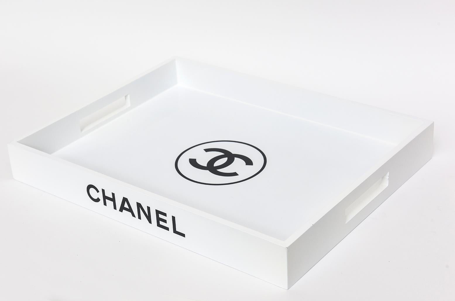 This contemporary Chanel white lacquered over wood tray was used for photographic staged photo shots and purposes in Los Angeles in the late 90's. It has black lettering saying Chanel. It was perhaps not used for any real Chanel shots. This is a