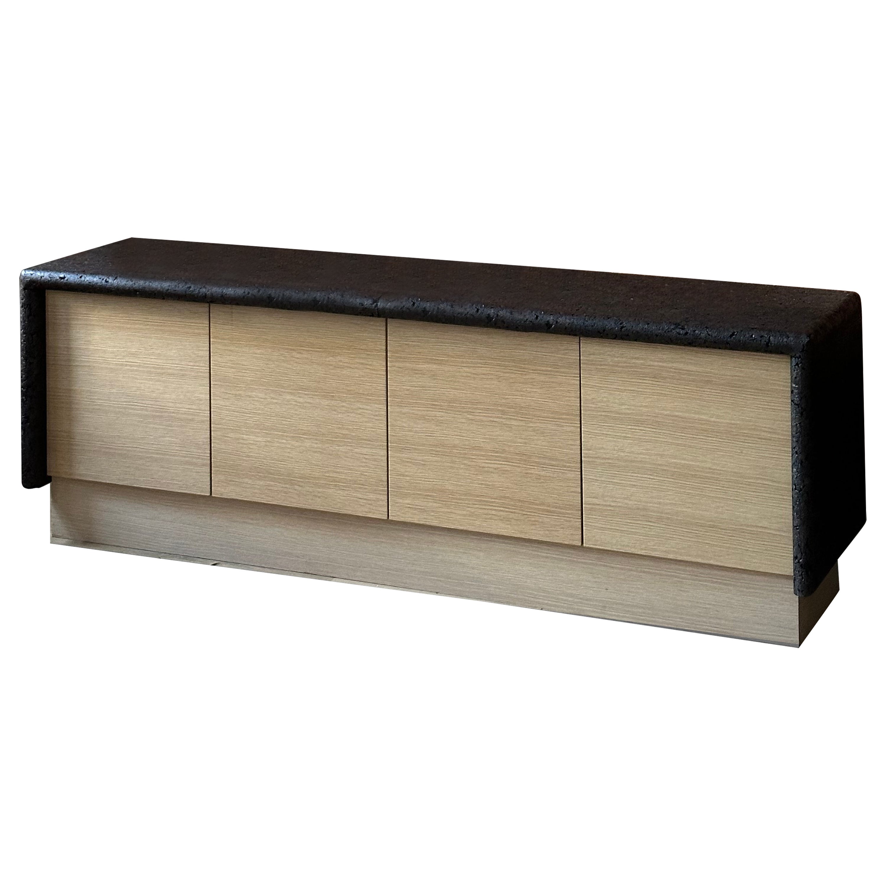 Questa credenza a quattro ante è una credenza e un mobile contenitore che può diventare il fulcro di qualsiasi spazio. Si ispira alla regione portoghese dell'Alentejo, che produce la maggior parte del sughero del mondo. Questo paesaggio