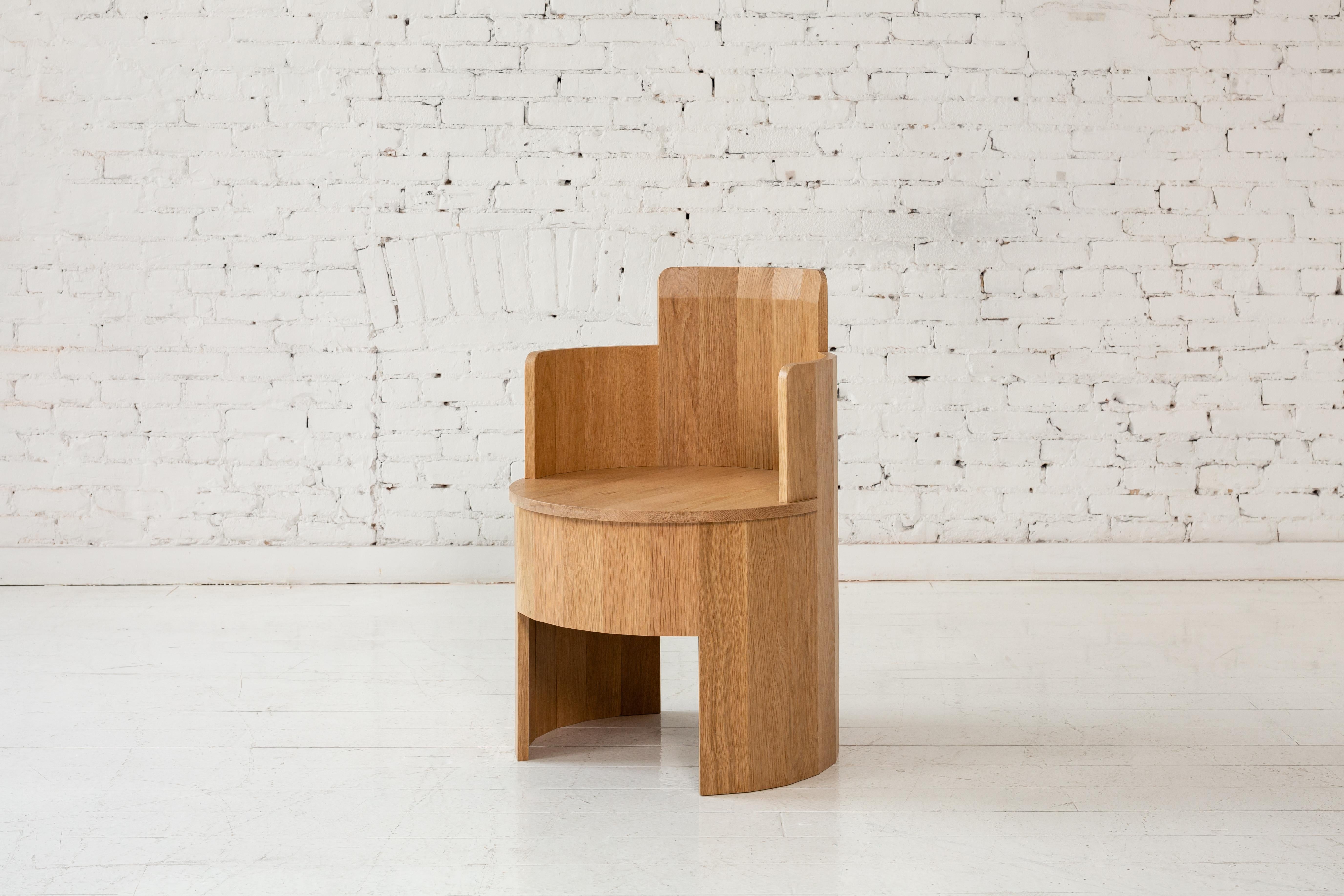 Cette chaise d'appoint en bois fait partie de la nouvelle Collection Dining Cooperage. Chaque pièce présente de grands éléments ronds facettés qui, avec son homonyme, font référence au métier traditionnel de tonnelier qui consiste à fabriquer des