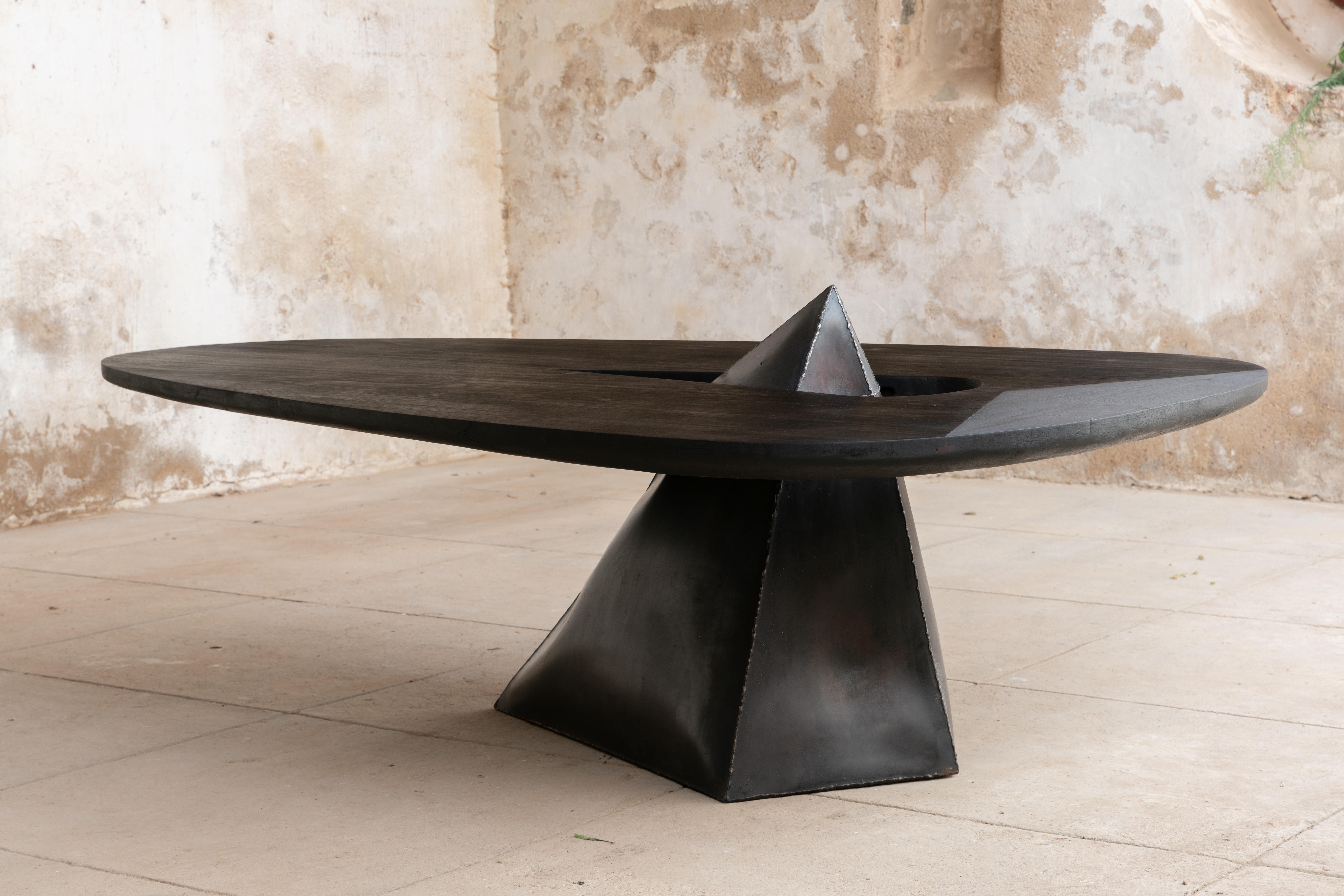 One-of-a-kind dining table.

The object is made from a Metal Volume that has been spontaneously shaped by an explosion, and hand treated to reach a soft touch. Part of a series of three furniture pieces, Metal Volumes have been exploded at various