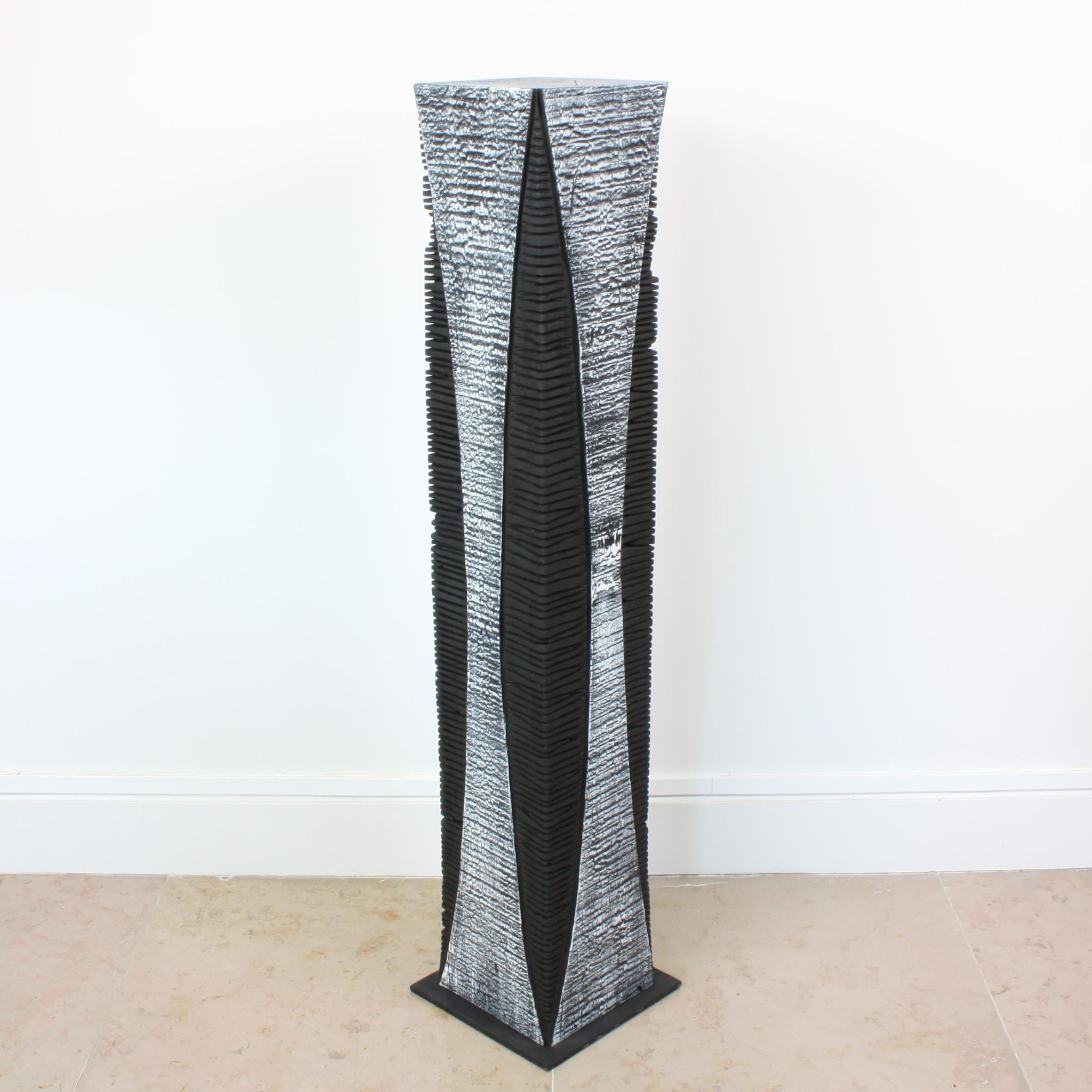 Beautifully textured contemporary wooden skyscraper sculpture on a metal stand. Artist Natacha Heitz finds the primary material for her extraordinary black and white wood sculpture in the Arolla pine. A stunning combination of surfaces and forms, it