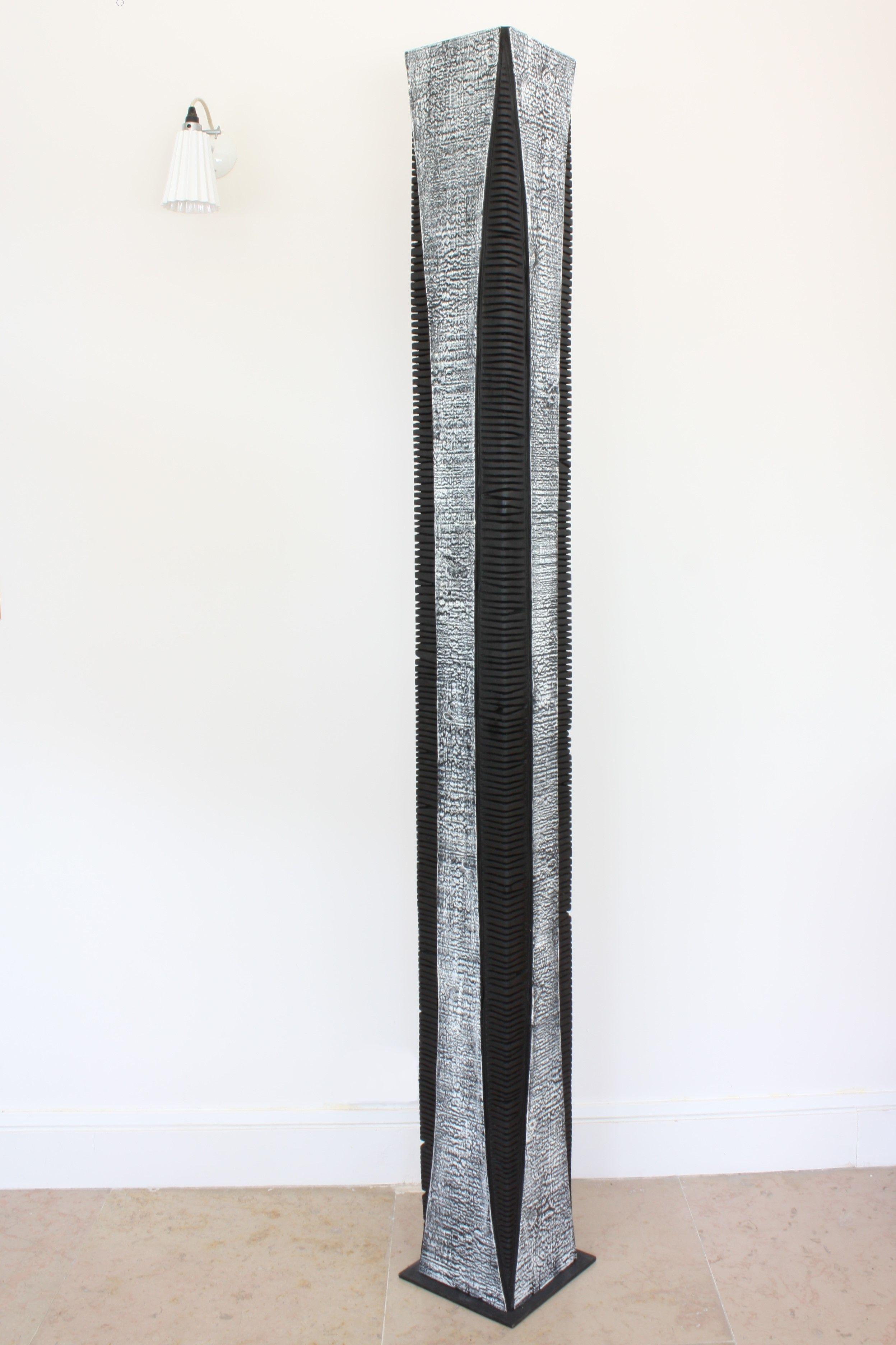 Beautifully textured contemporary wooden skyscraper sculpture on a metal Stand. Artist Natacha Heitz finds the primary material for her extraordinary black and white wood sculpture in the Arolla pine. A stunning combination of surfaces and forms, it