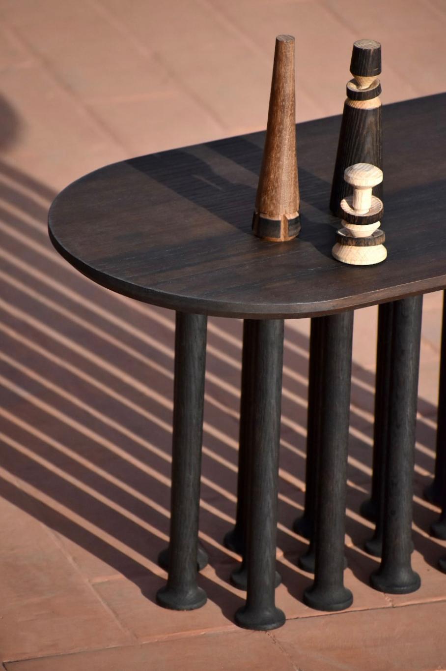 Molinillo is a collection of auxiliary and center tables designed by the Colección Estudio. Each of the legs of the tables were made manually and its intense black color was achieved by carbonizing the wood, a finish inspired by mills. The covers,