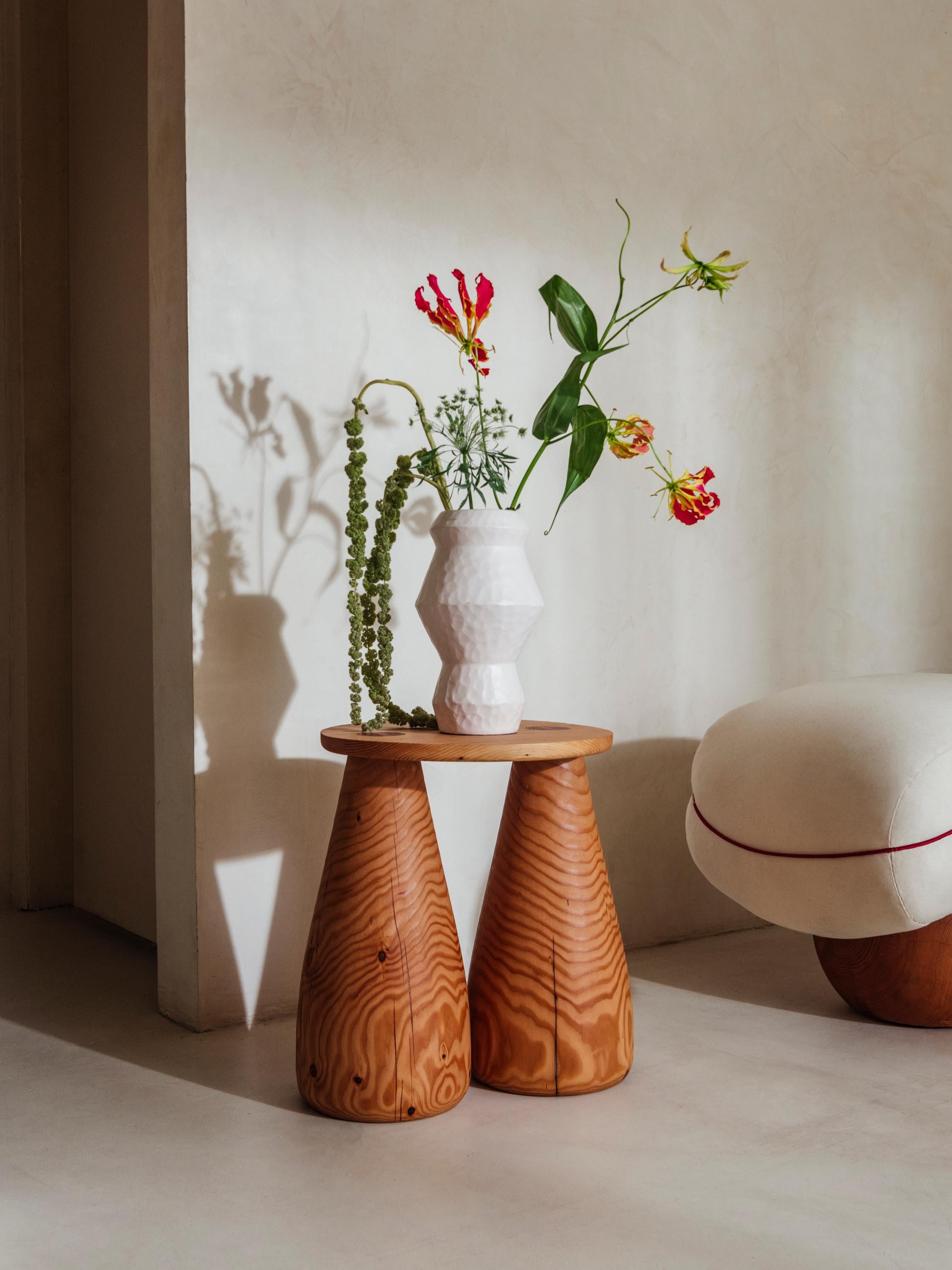 Als Teil der zweiten Kollektion von Studio Sam Klemick wurde The Wooden Side Table im Jahr 2023 vorgestellt. Der handgefertigte Holztisch wird in Los Angeles, Kalifornien, hergestellt. Die großen glockenförmigen Beine wurden auf der Drehbank