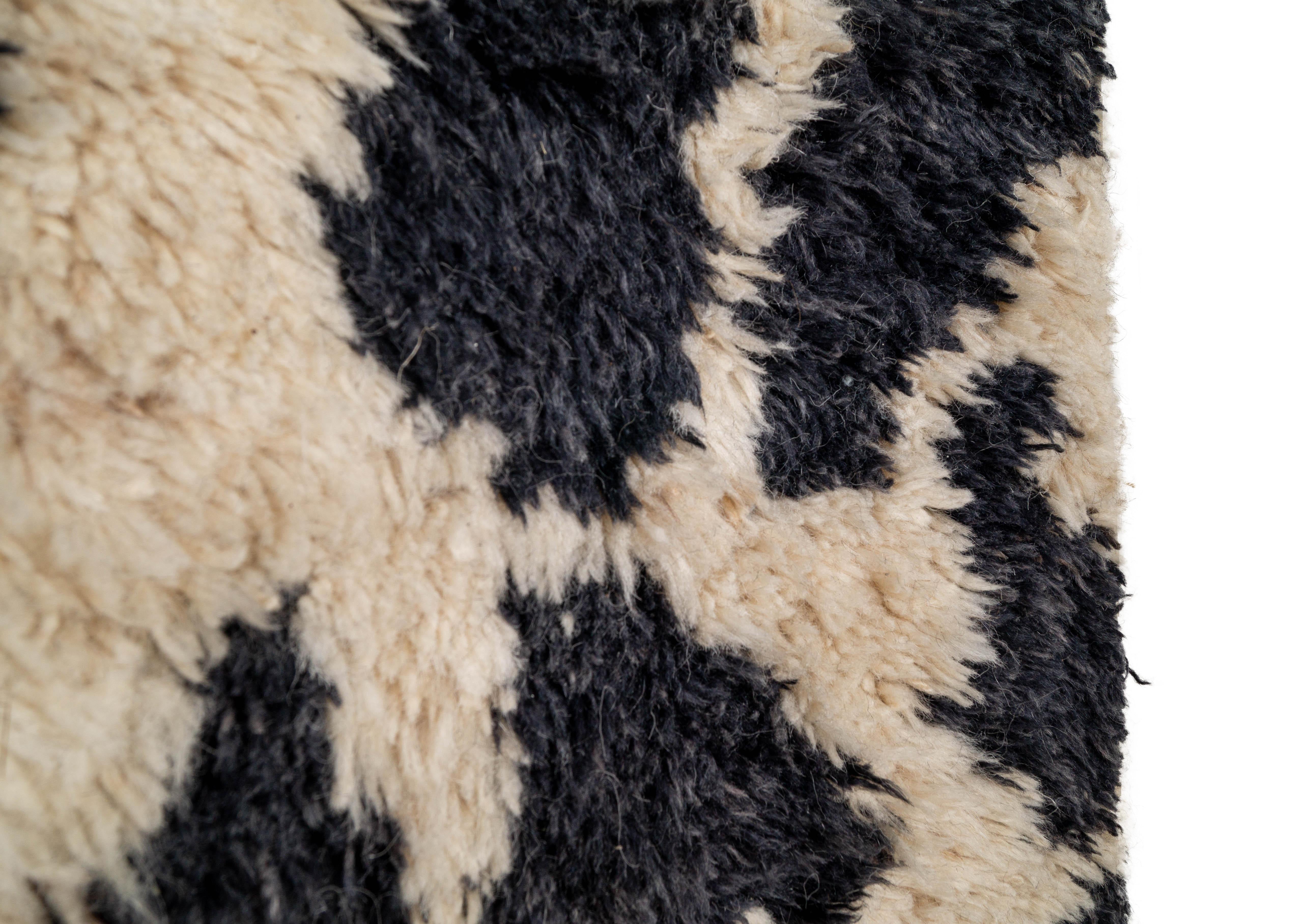 Level up the sophistication of your interior space with our Contemporary shag rug. Made from premium Berber wool, this shag rug features a cream and black spotted design, creating a modern and stylish look that will add an extra touch of luxury to