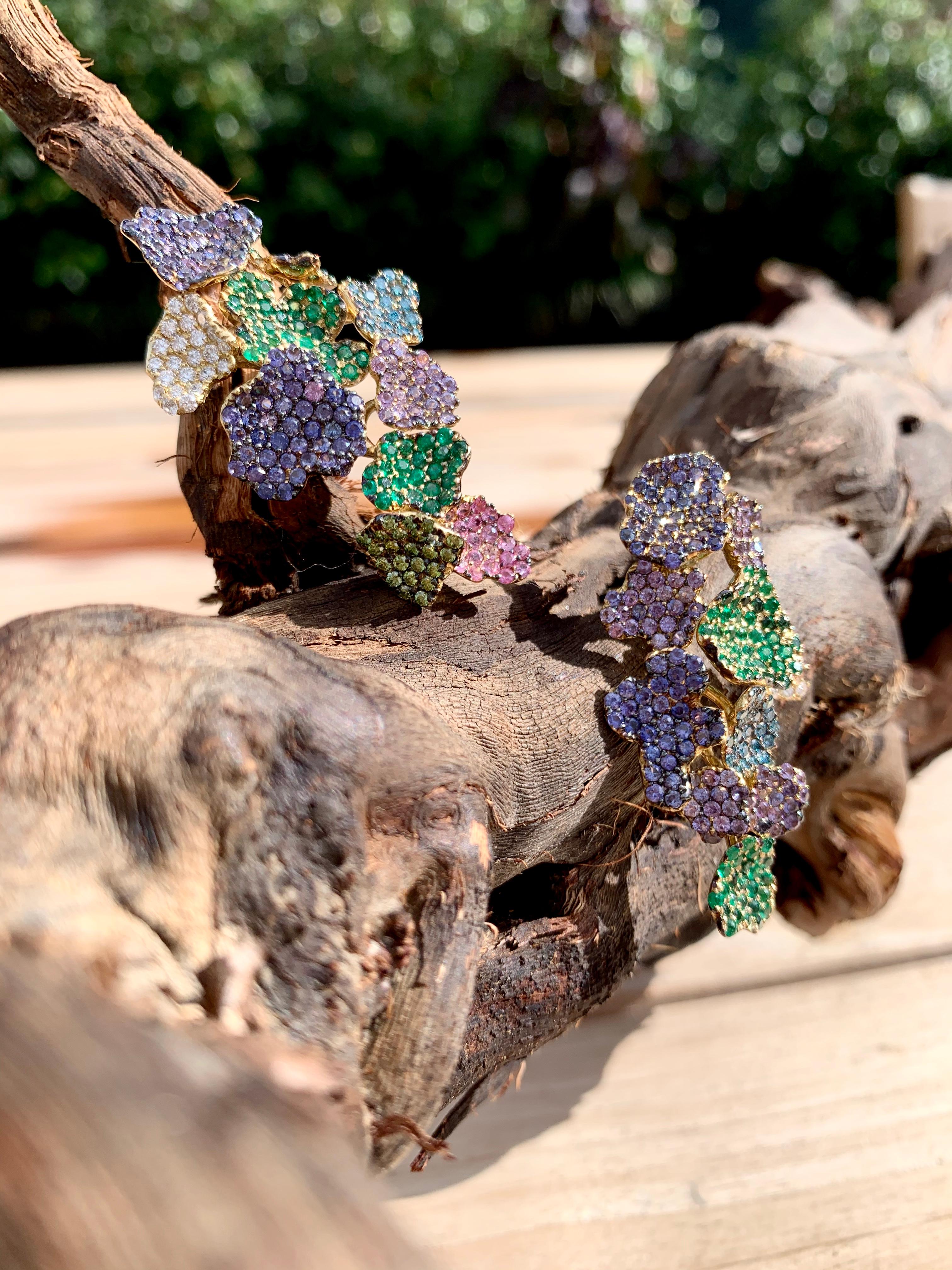 Rosior by Manuel Rosas Contemporary Long Earrings featuring different flowers, each one handmade in 19.2 Karat Yellow Gold and Set with:
- 253 Purple Sapphires with 4,21 ct,
- 22 Pink Sapphires with 0,40 ct,
- 126 Emeralds with 1,63 ct,
- 49 White