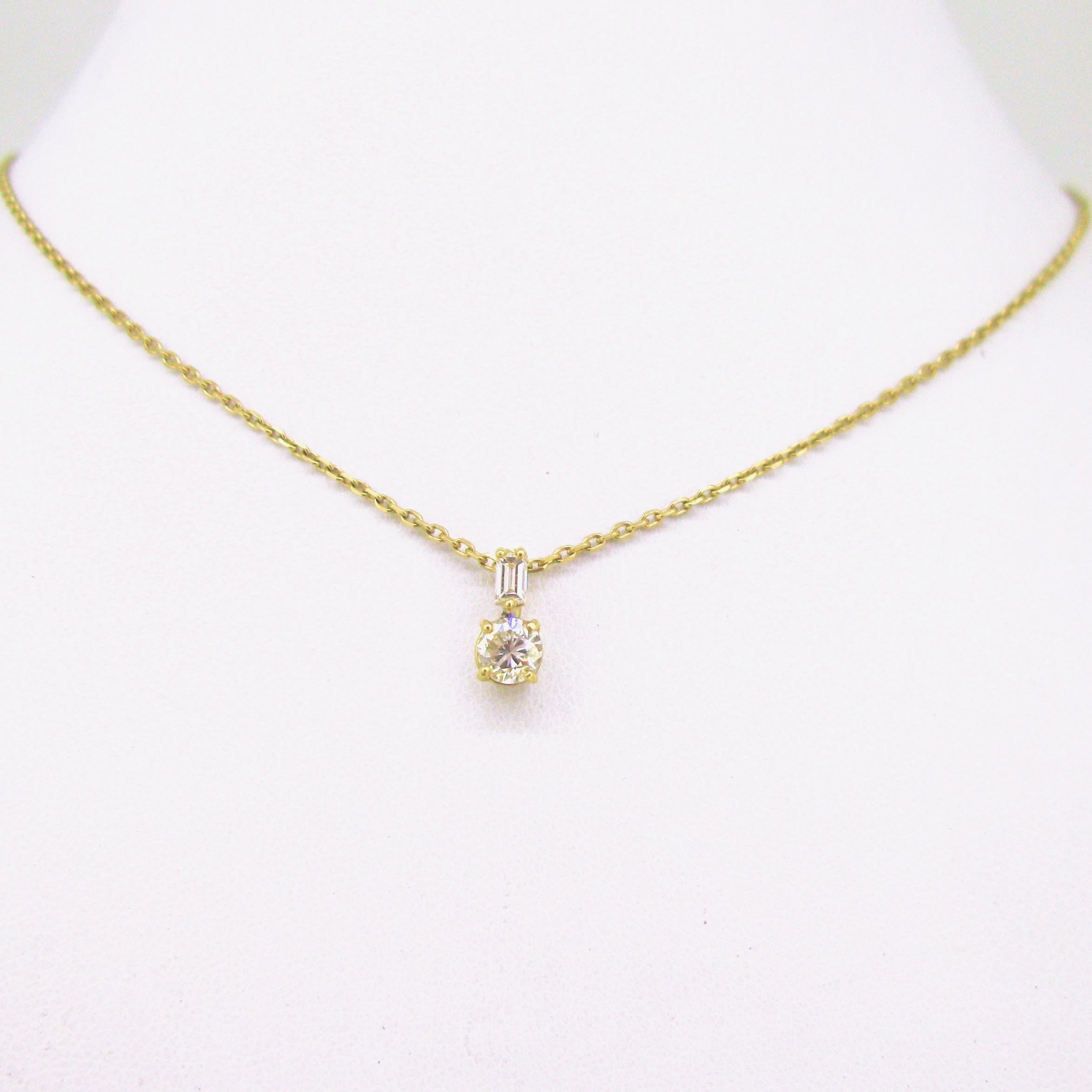 This timeless pendant on chain was made in 18kt yellow gold. The pendant is set with a round diamond of 0.35ct approximately, topped with a baguette diamond of 0.15ct approximately.. The chain is made in 18kt gold and the length is adjustable. This