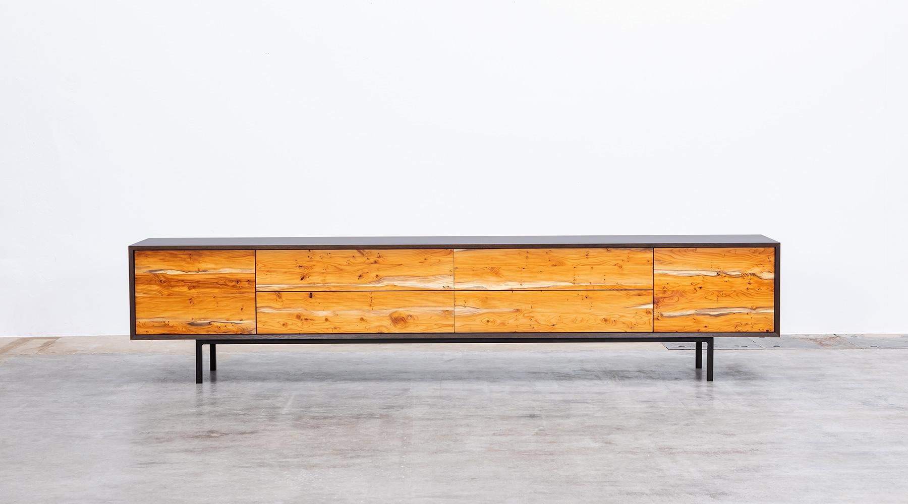 Sideboard by contemporary German artist Johannes Hock. The front of the doors and drawer of this unique piece are made of massive yew wood, the corpus is in black hpl on black metal legs. Manufactured by Atelier Johannes Hock.

Hock learned