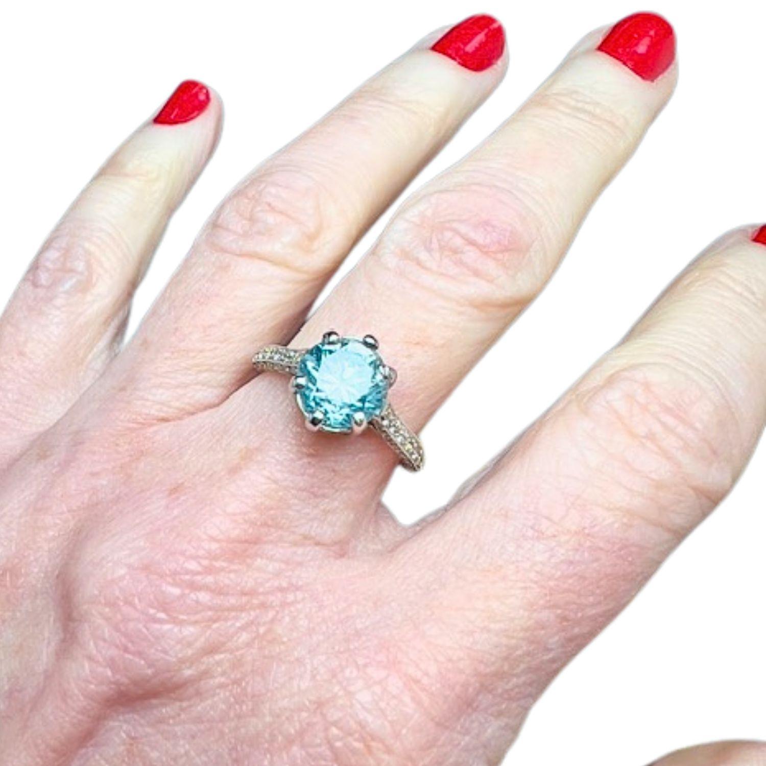 This contemporary ring is crafted in 18K gold and features a central zircon along with brilliant-cut Diamonds. It has a weight of 4.91 grams and is sized 14.5 ES /54.5 EU
The Diamonds total 0.50 carats and are of VS clarity and H-G color grade.
 The