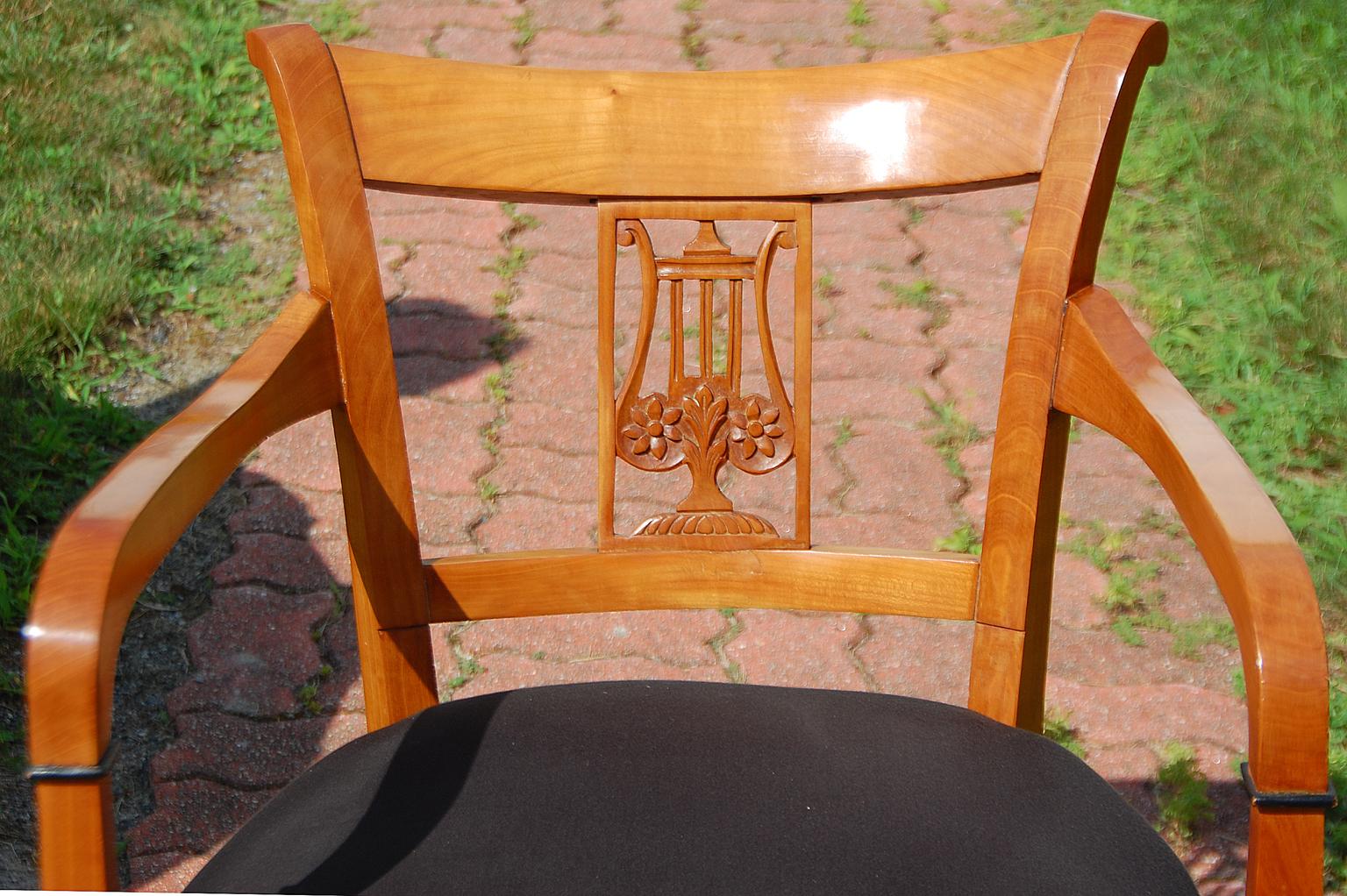 Continental Biedermeier cherry armchair with carved lyre back, sweeping arms leading to ebonized delicate collar and on to tapered legs; over upholstered seat in black cotton, 19th century. $1,500.