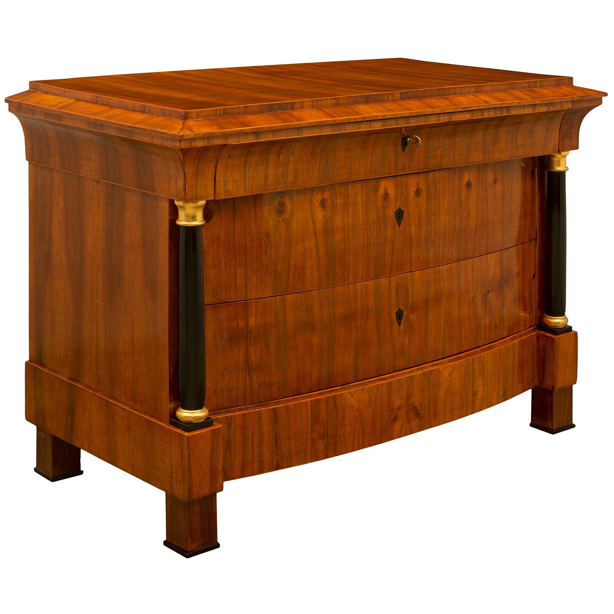 A striking and extremely unique Continental 19th century Biedermeier period Walnut, ebonized fruitwood and giltwood commode. The three drawer chest is raised by elegant block feet with delicate ebonized Fruitwood fillets below the straight frieze