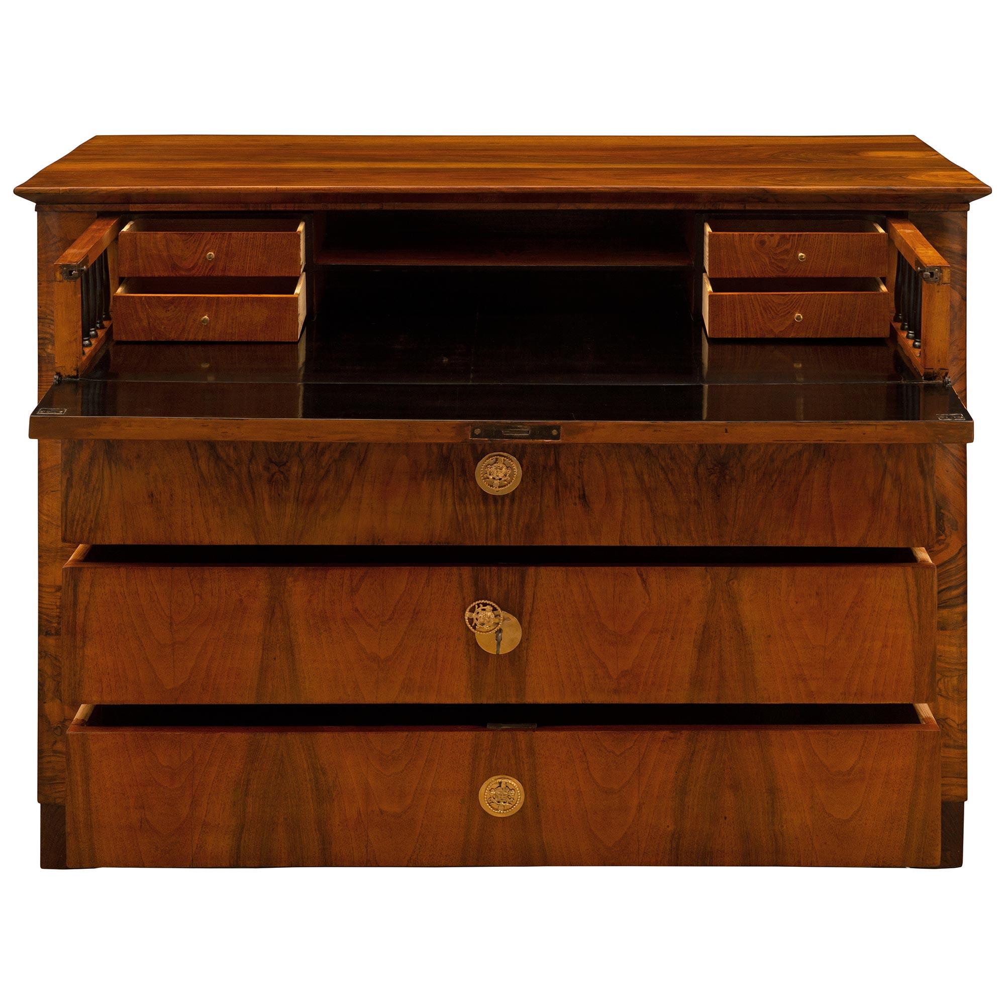 An exceptional and unique Continental 19th century Biedermeier st. flamed Mahogany, ebonized Fruitwood, and ormolu butler's desk/commode. The eight drawer chest is raised by square feet below the straight apron. At the center are four drawers