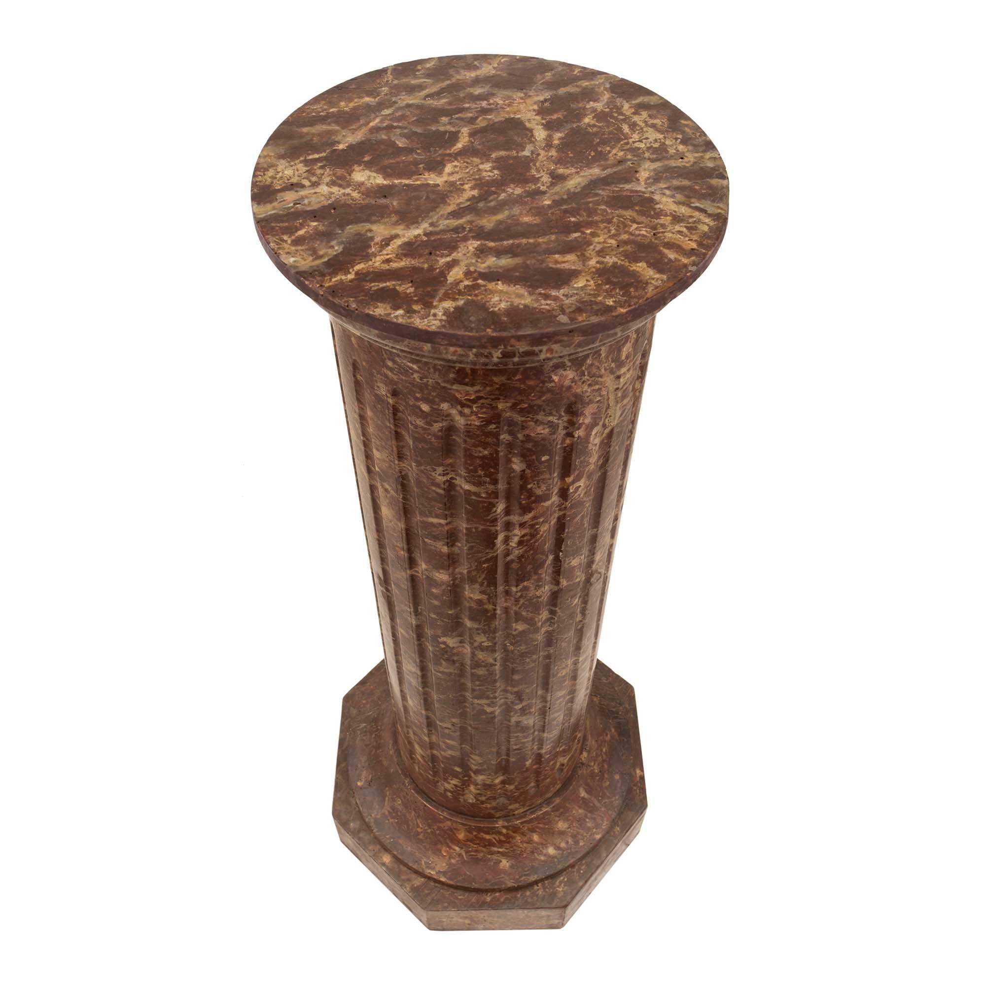 A Continental 19th century classical st. faux marble column. The column in solid oak retains all of its original and extremely realistic marble finish. The column is raised by a polygoAlly shaped base below a large concave band all below the fluted