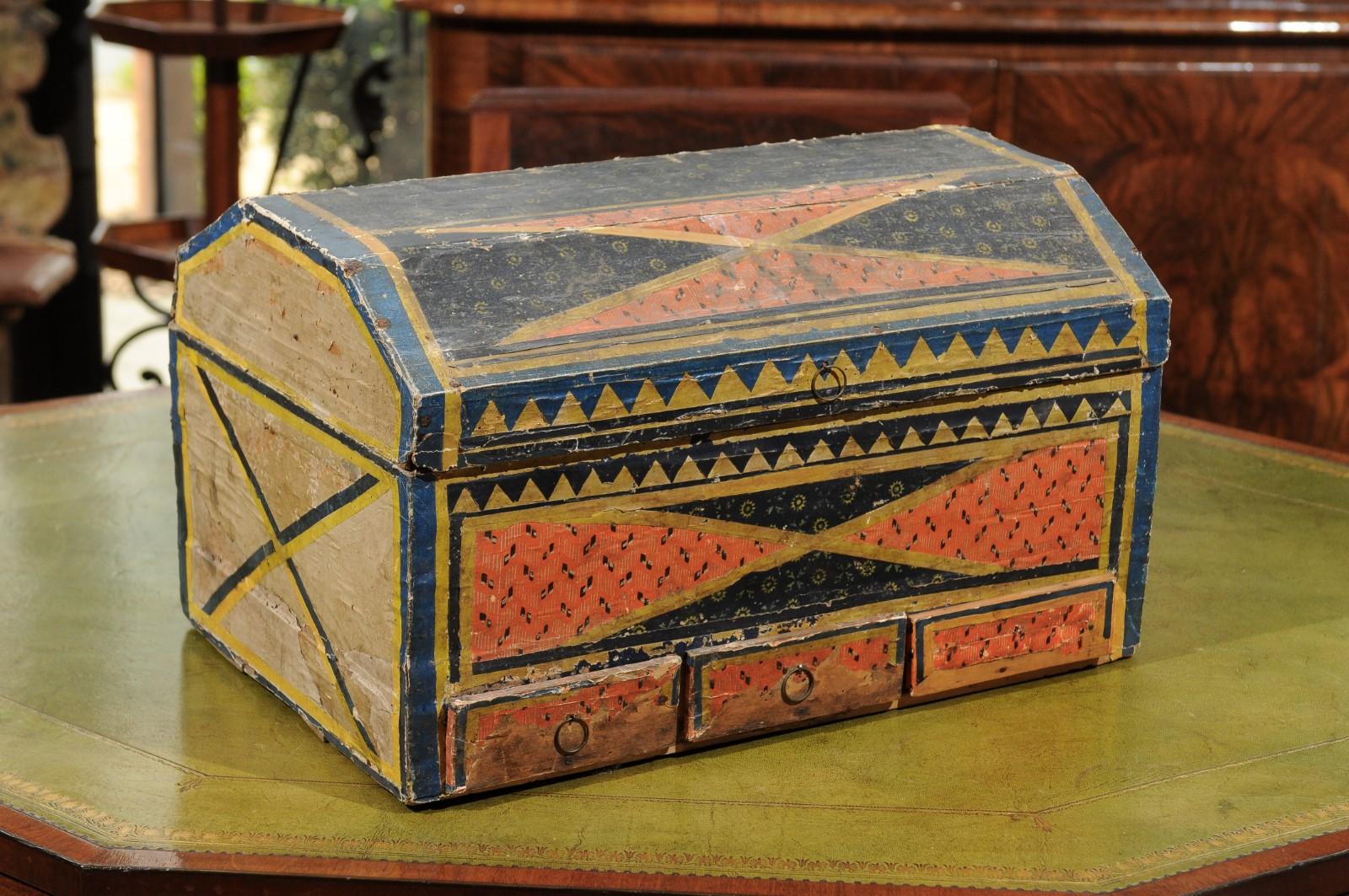 The continental 19th century decorated painted paper lined wooden box featuring geometric design and orange and blue hues. The box with 3 lower drawers.



 