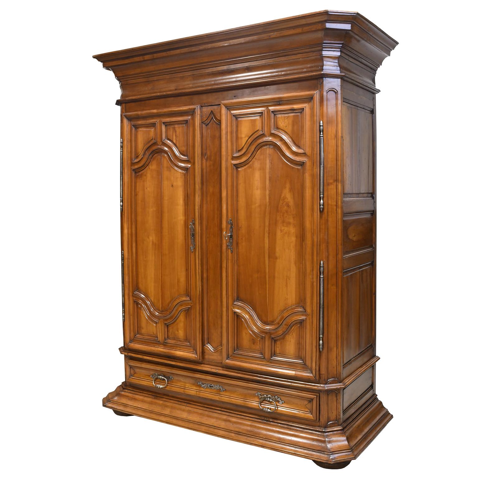 This beautiful and massive armoire in French walnut, has been outfitted as a bar cabinet. The interior features a wine rack that will hold 47 bottles, a slab of green marble has been added with cupboards flanking 2 drawers in the middle. The