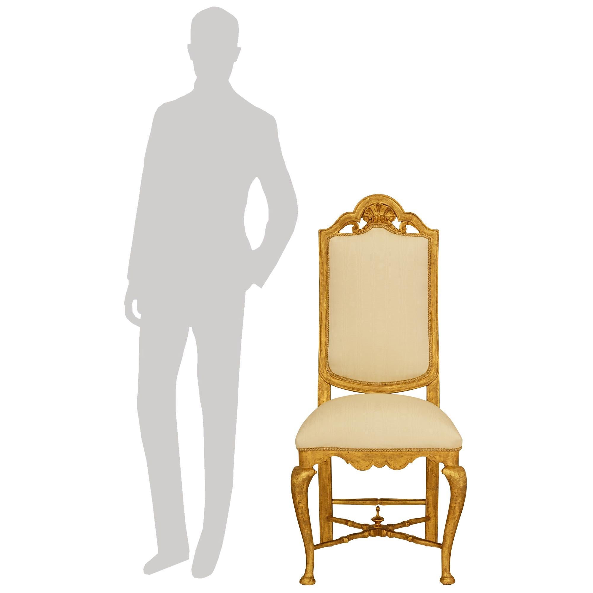 Un magnifico set completo di alta qualità di dodici sedie da pranzo in legno dorato Luigi XV del XIX secolo. Ogni splendida sedia è rivestita in tessuto Fabrice di seta color crema e presenta gambe dritte sullo schienale e gambe a cabriola nella