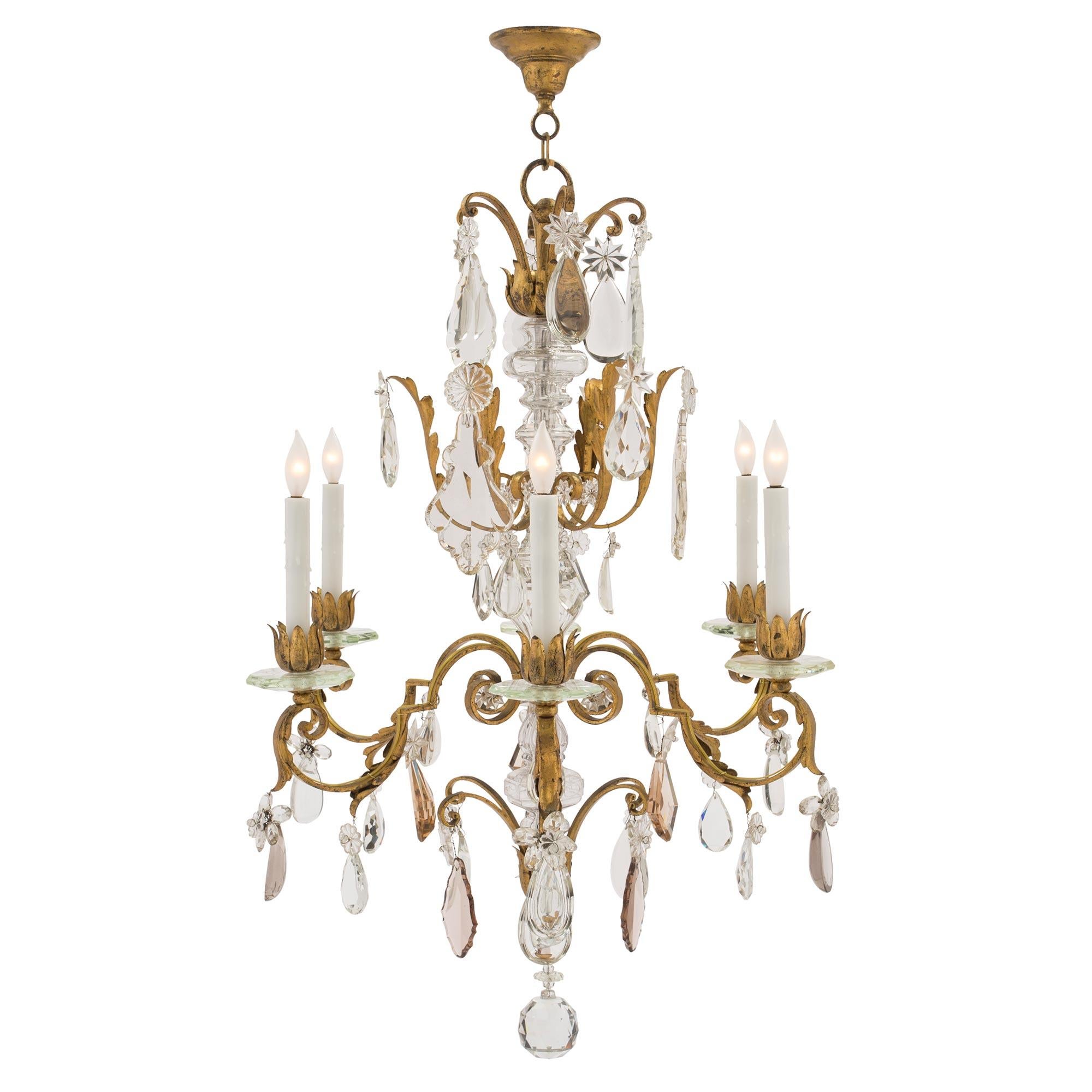 A wonderful continental early 19th century Louis XV st. gilt iron, crystal, six light manor style chandelier. The chandelier is centered by a beautiful and uniquely cut solid crystal ball below fine gilt metal leaves. Branching out from the elegant