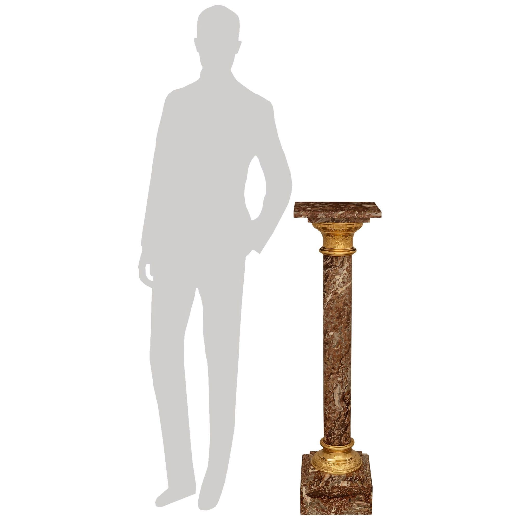 An attractive and most decorative Continental 19th century Louis XVI st. Ormolu and Rouge Royale marble pedestal. This lovely pedestal is supported on a square stepped base with a mottled and foliate patterned Ormolu socle above. Leading up the