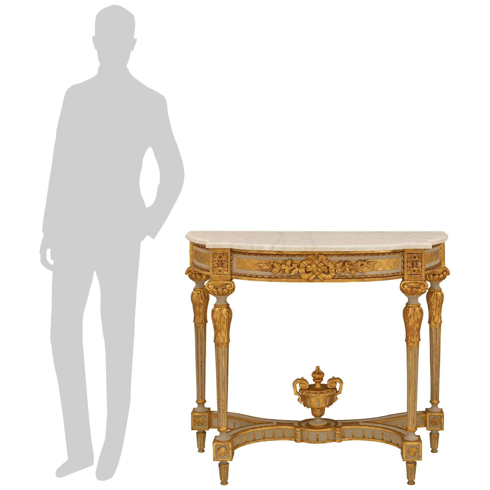 Elegante y muy decorativa consola continental del siglo XIX, de estilo Luis XVI, de madera patinada, giltwood y mármol. Esta impresionante consola independiente se eleva sobre cuatro patas estriadas de madera patinada con adornos de madera dorada