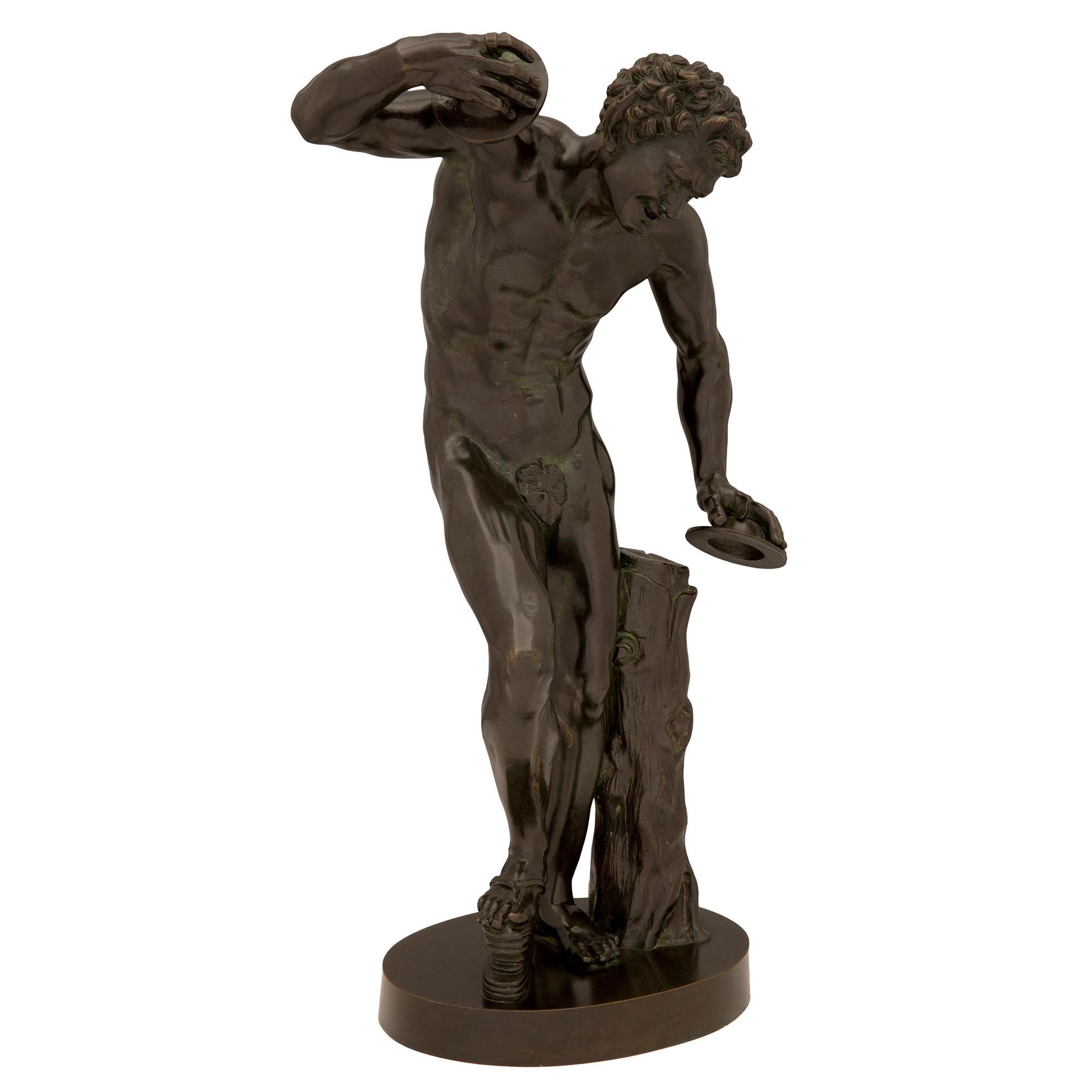 A handsome and high quality Continental 19th century patinated bronze statue of a dancing faun with cymbals, signed 'Musée de Florence'. The statue is raised by a circular base where the signature is displayed. Above is the handsome and richly