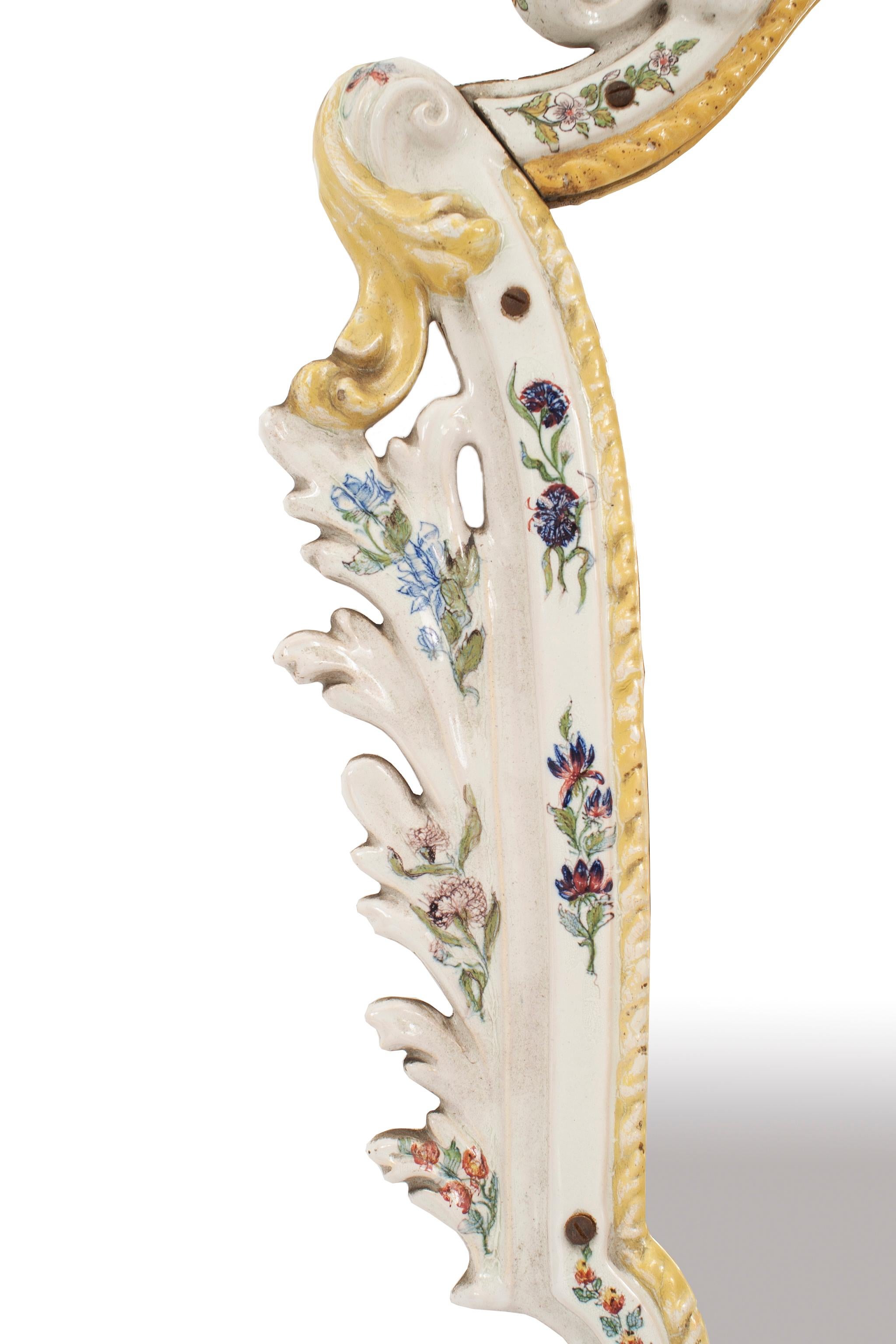 Continental, possibly German, '19th centurty' white porcelain keystone shaped wall mirror with yellow trim and floral decoration having a floral pediment (similar to VCG005).
 
  