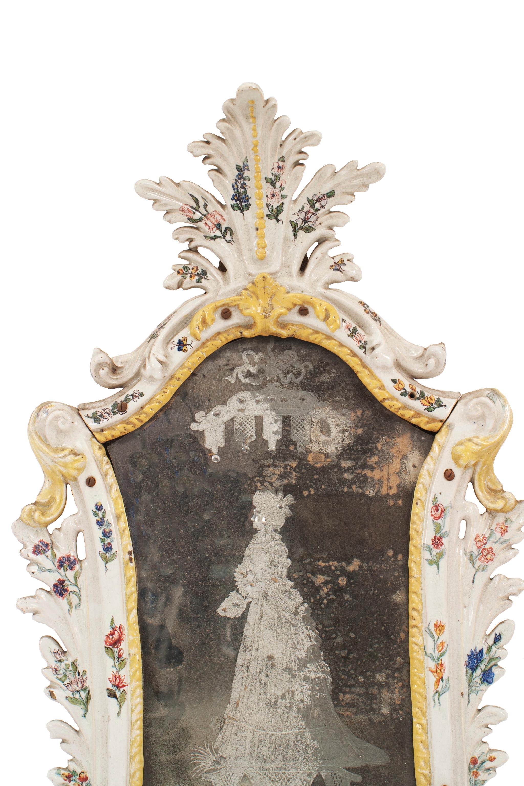 Continental (possibly German 19th century) white porcelain keystone shaped wall mirror with yellow trim and floral decoration having a floral pediment and etched glass with a figure (similar to VCG004).

  