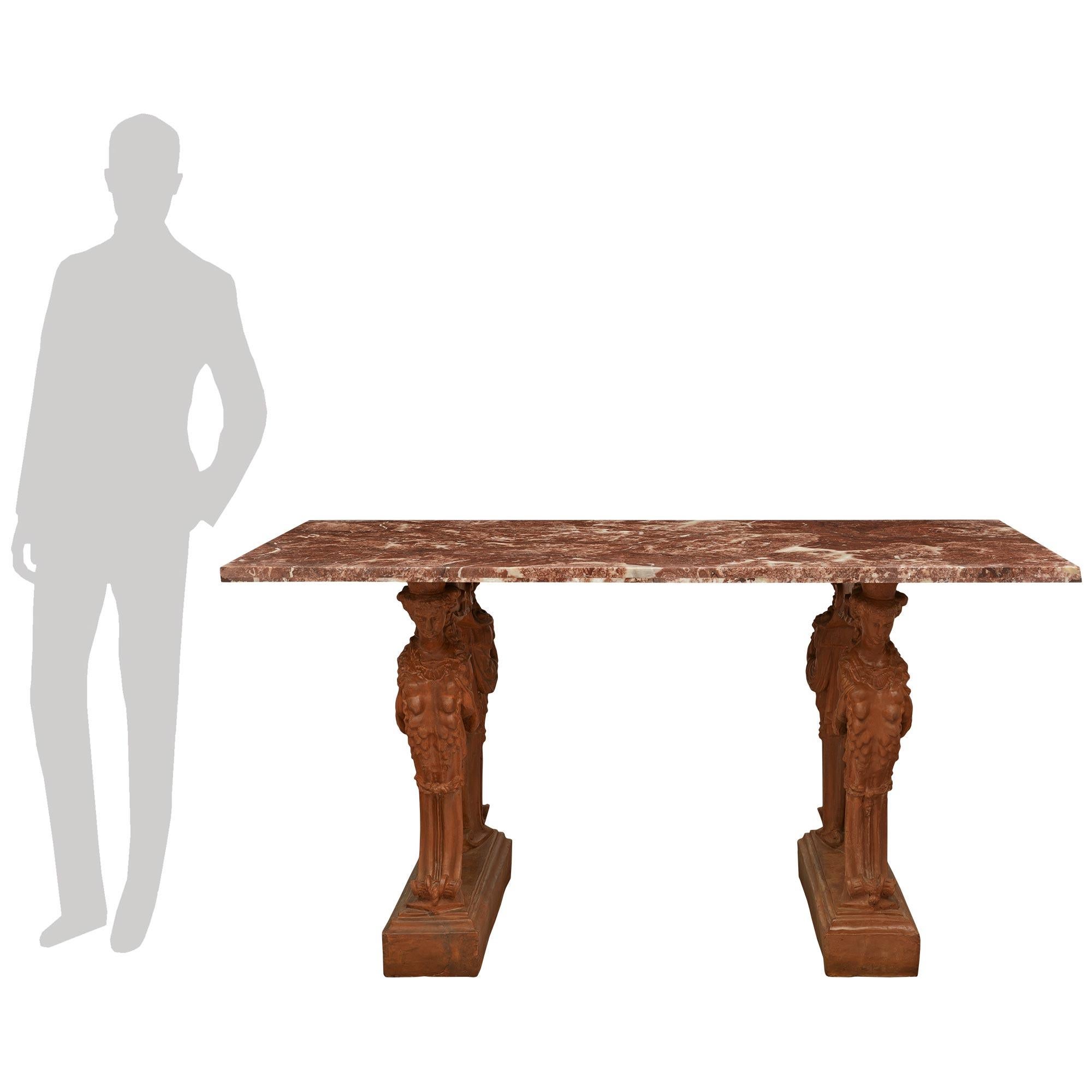 A handsome and most decorative Continental 19th century Terra Cotta and marble center table. This wonderful rectangular table is raised on two pierced Terra Cotta bases with a mottled plinth below scrolled female figures wearing classical attire.