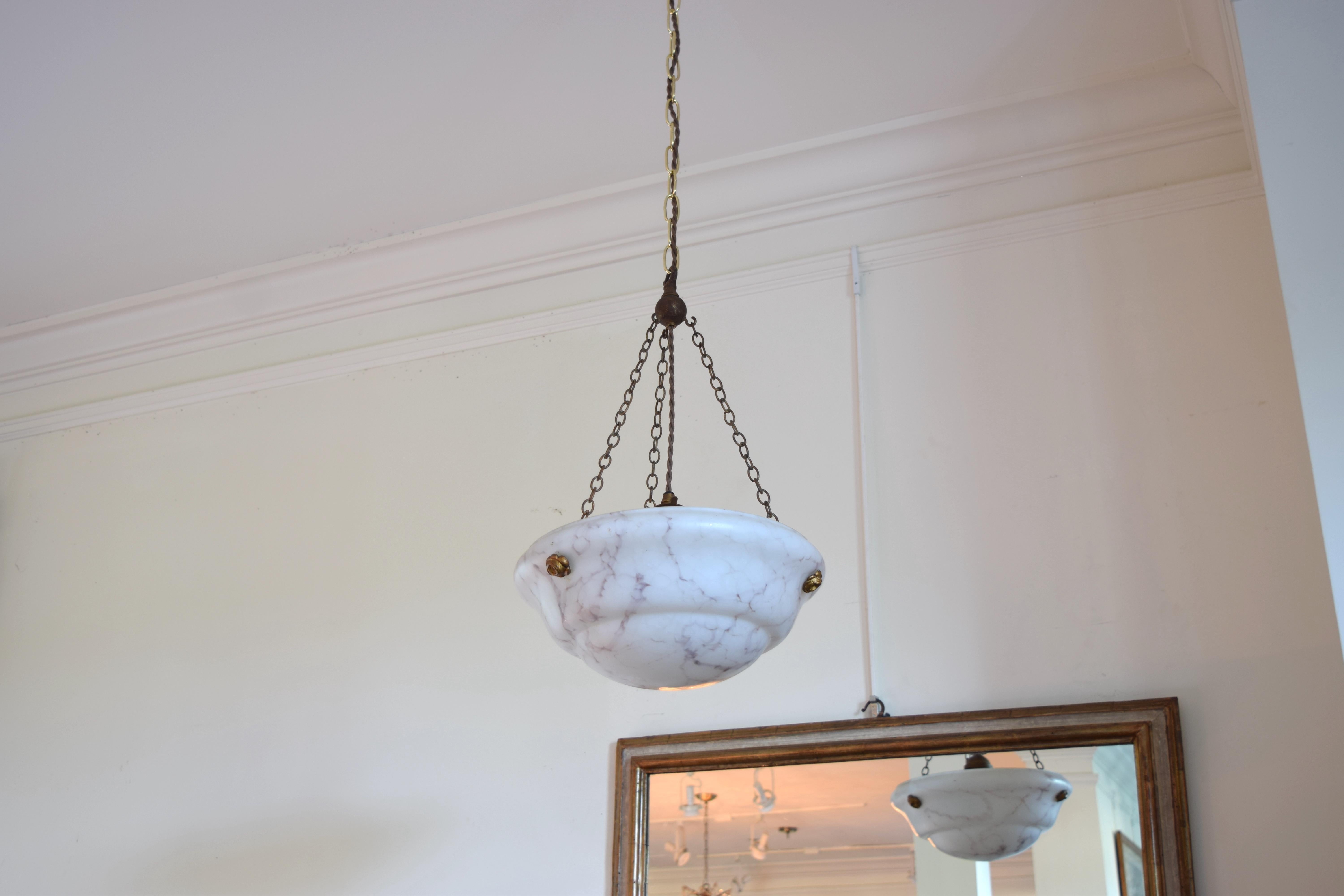 the dome shaped alabaster bowl with light veining suspended from small chains and attached to the fixture with stylized brass fittings, wired with 3 lights on the interior
