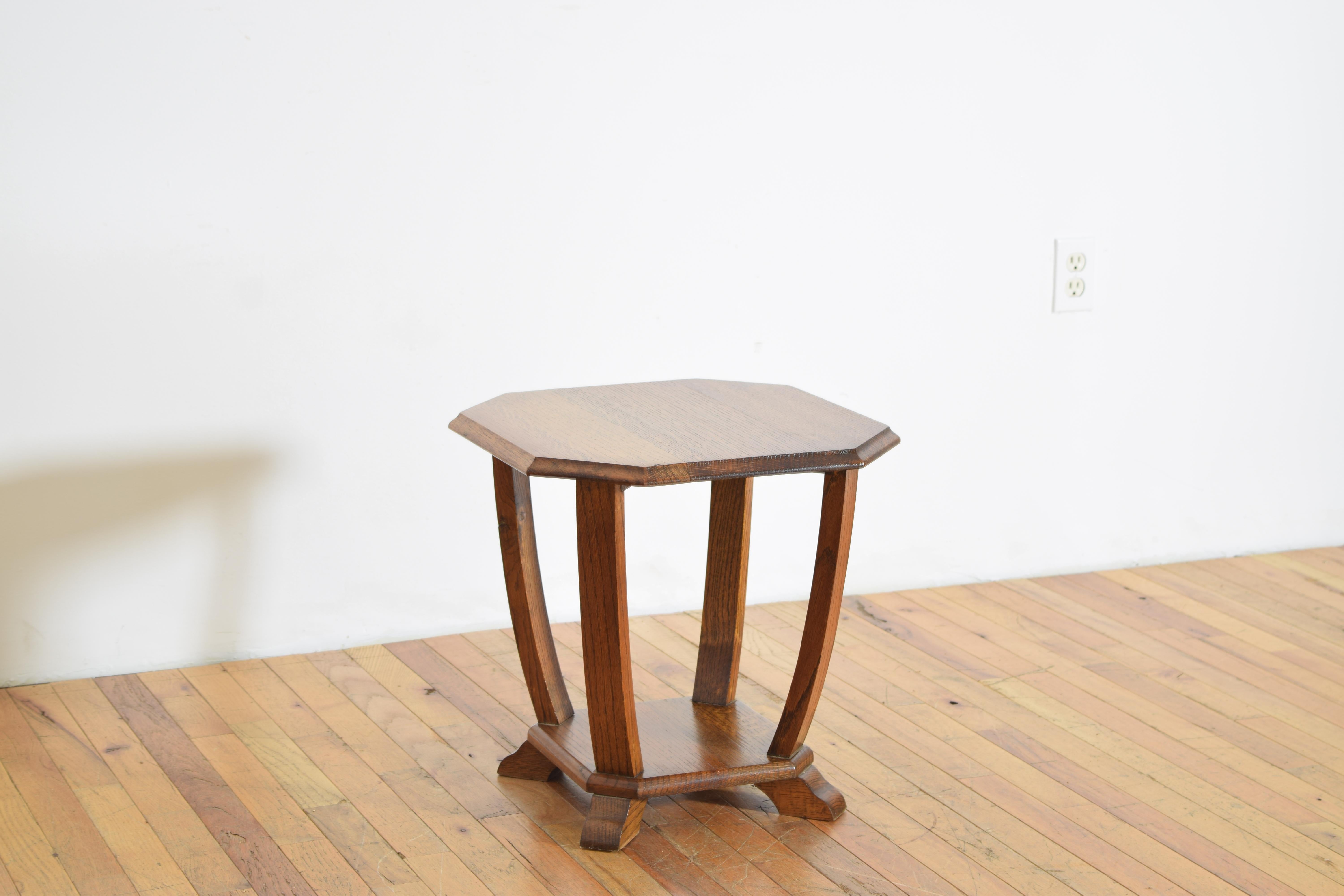 petite oak side table with a octagonal top, raised on four tapered, curved legs and set over a shaped platform base