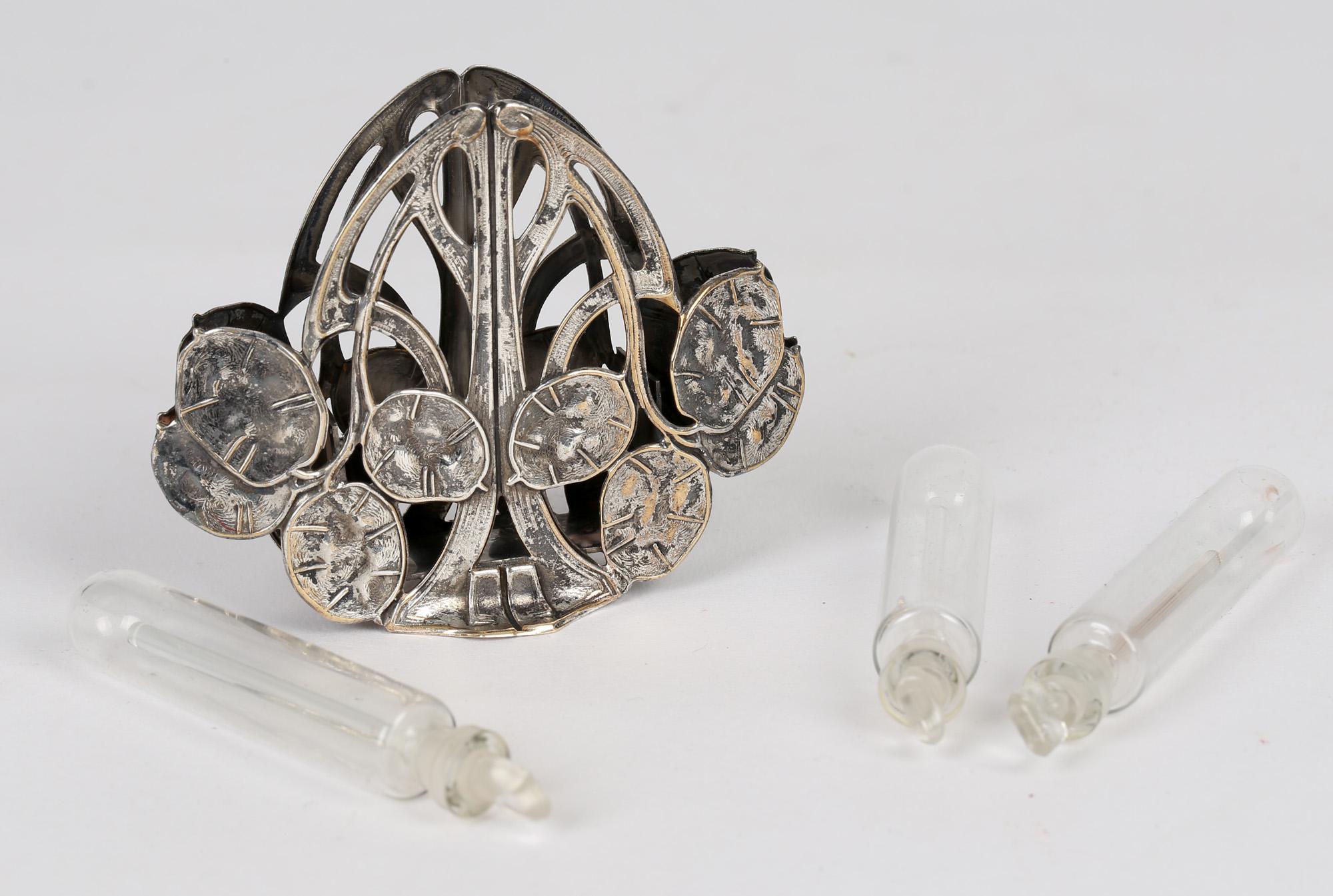 A very stylish Continental Art Nouveau silver plated seed pod scent bottle holder with three scent bottles dating from around 1900. The holder is formed from a series of seed pod designs on raised trailing stems with openwork designs with a small