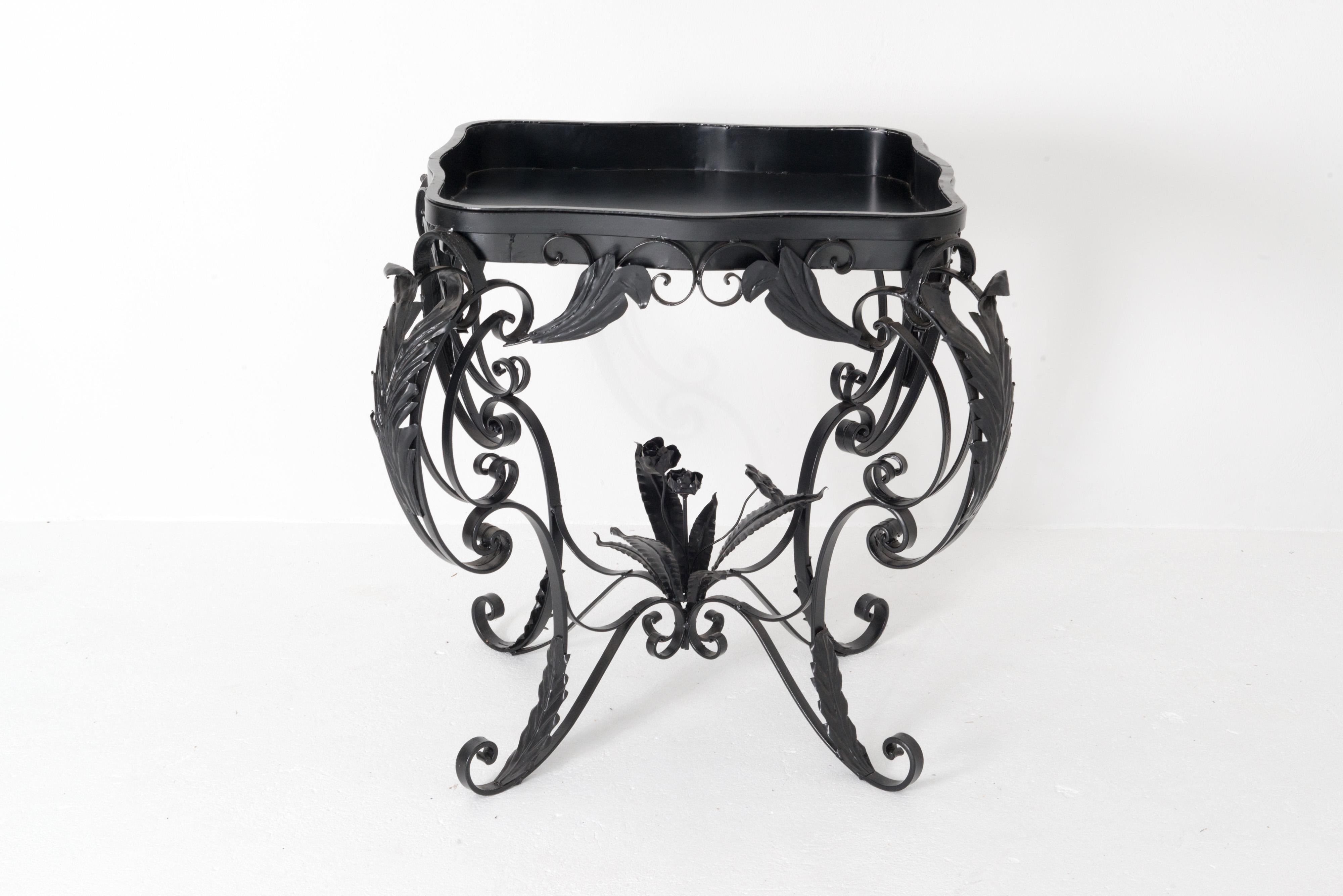 Foliate French wrought iron planter with inset tray. Corners are embellished with curving iron leaves. The four wrought iron stretchers converge in the center at a delicate wrought iron bouquet of flowers. An unusual antique piece in excellent