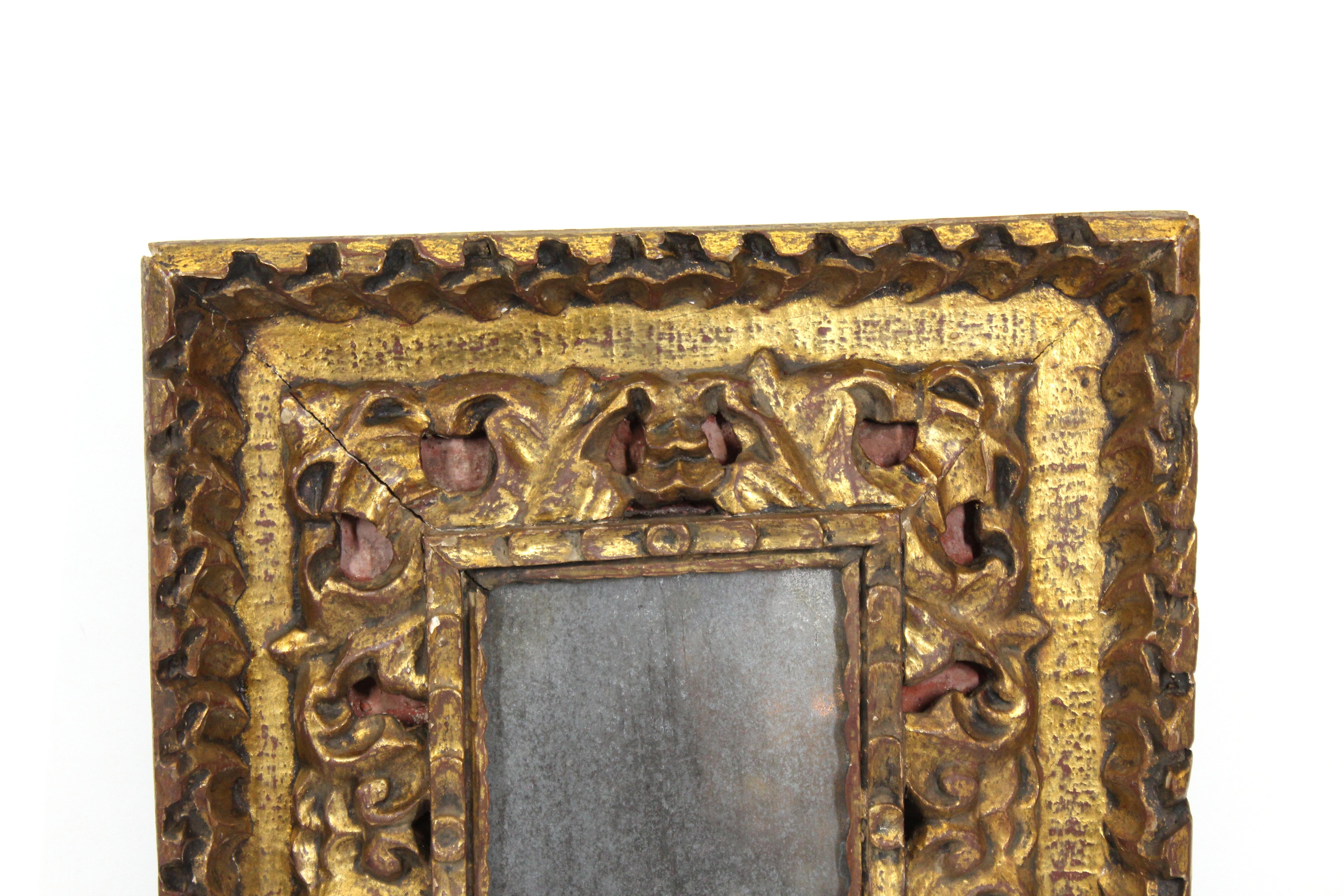 Kontinentaler Barockrahmen aus vergoldetem Holz mit stark geschnitztem Blattwerk und roter Hintergrundfarbe. Das wahrscheinlich im frühen 19. Jahrhundert in Europa hergestellte Stück wird mit einem antiken Spiegeleinsatz geliefert. In tollem antiken