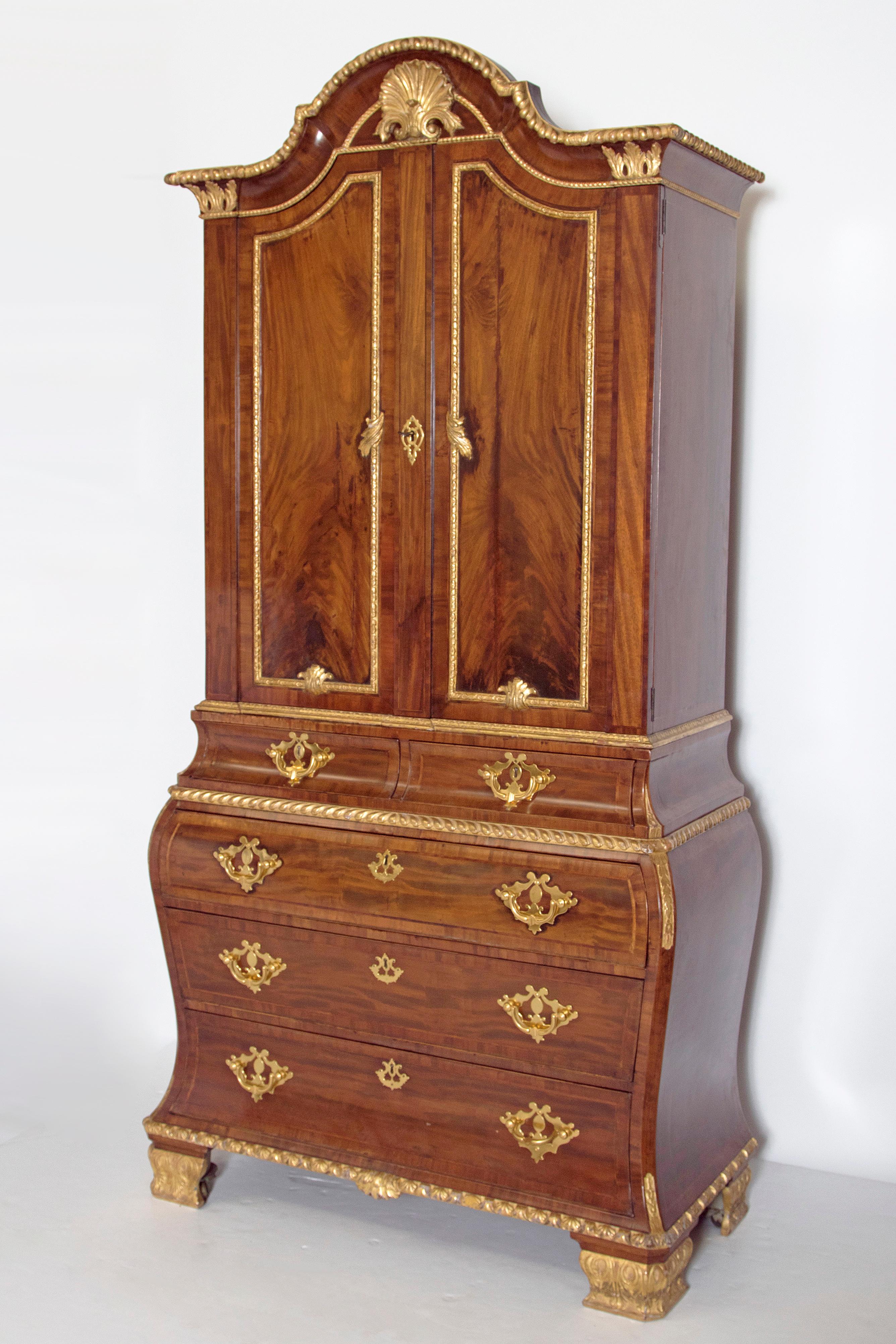 A very good quality early 20th century Continental mahogany and parcel-gilt rococo style secretary. In three parts, having a dome top cornice above two solid doors with key. Interior fitted with two adjustable shelves and siting on two small