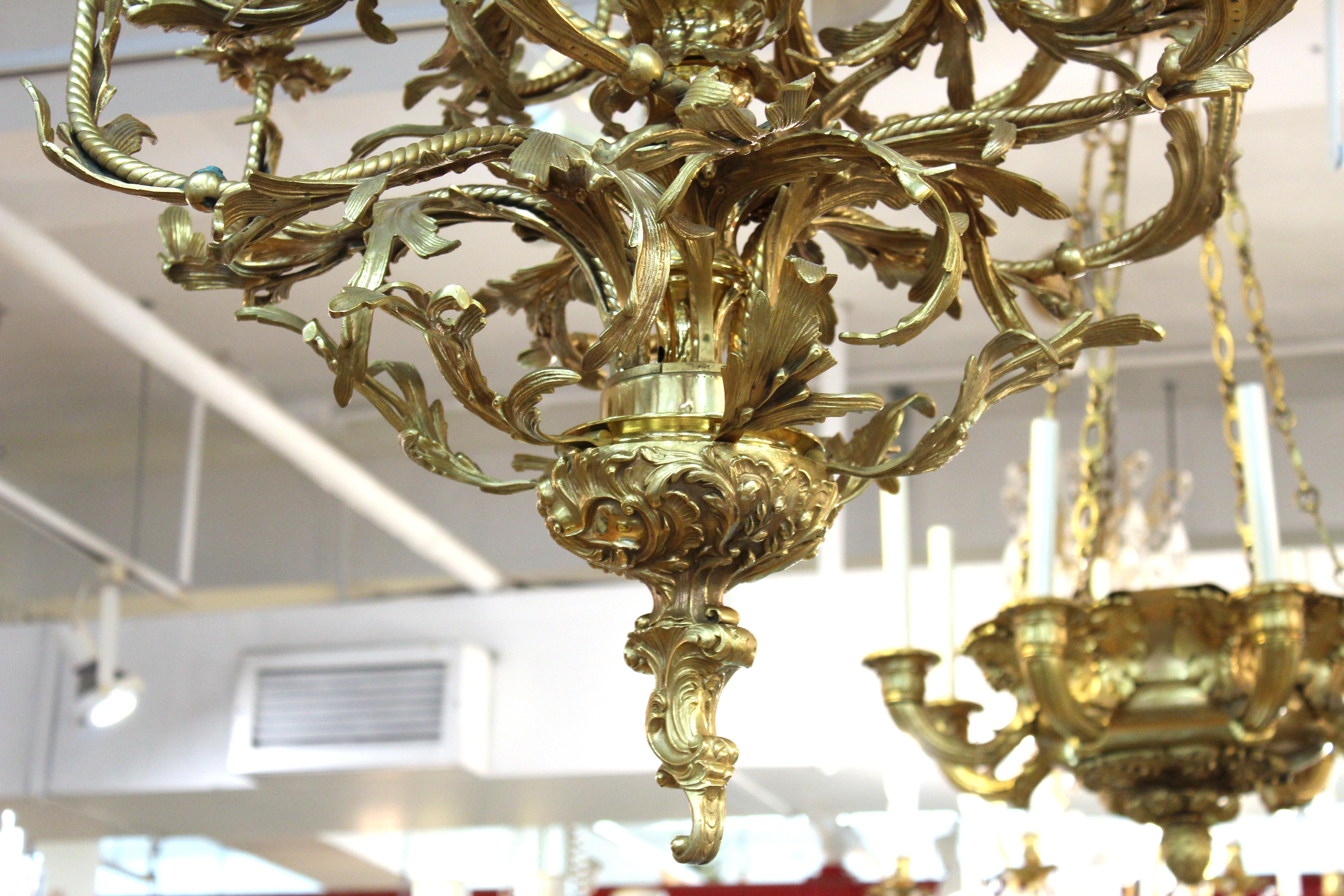 Continental Baroque style twelve arm ormolu chandelier with bronze putto seated in stem. Measures: 55
