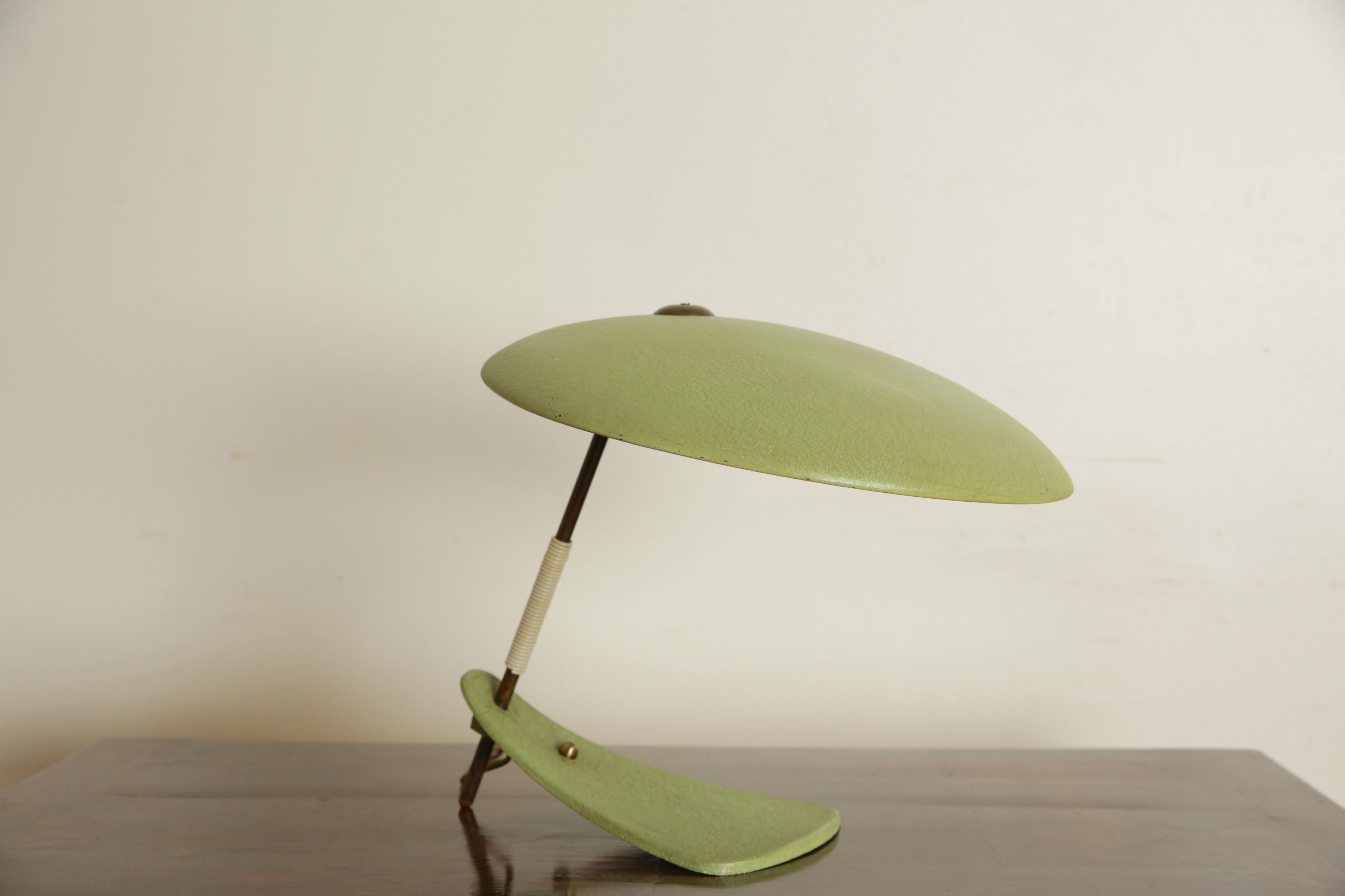 Having a circular shade raised on a slanted post atop a shaped base, cord switch, posted measurements are facing the lamp