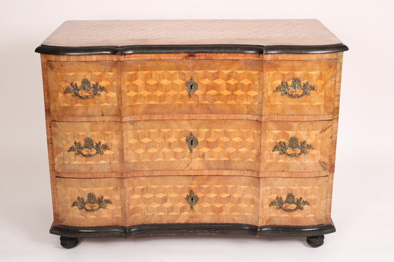 Continental (probably German) Biedermeier cube parquetry chest of drawers with pull out writing slide, circa 1835. With a cube parquetry top, front and sides. Ebonized top border, base molding and feet.